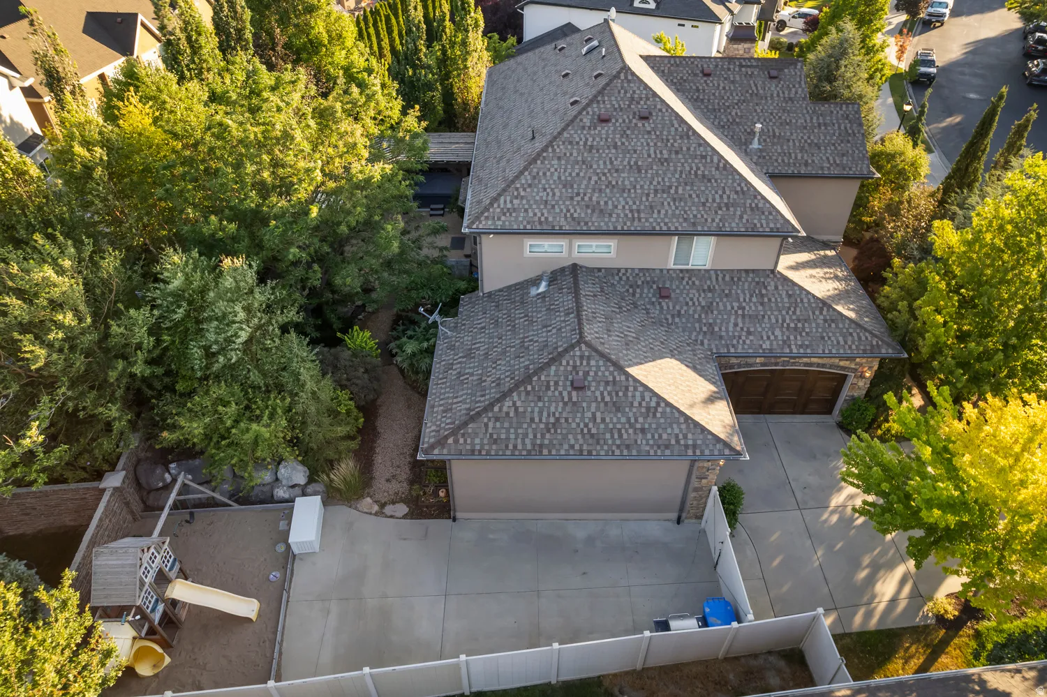 Spacious residence featuring a multi-gabled roofline with asphalt shingles, an attached garage with a dark wood-finish door, and a paved driveway