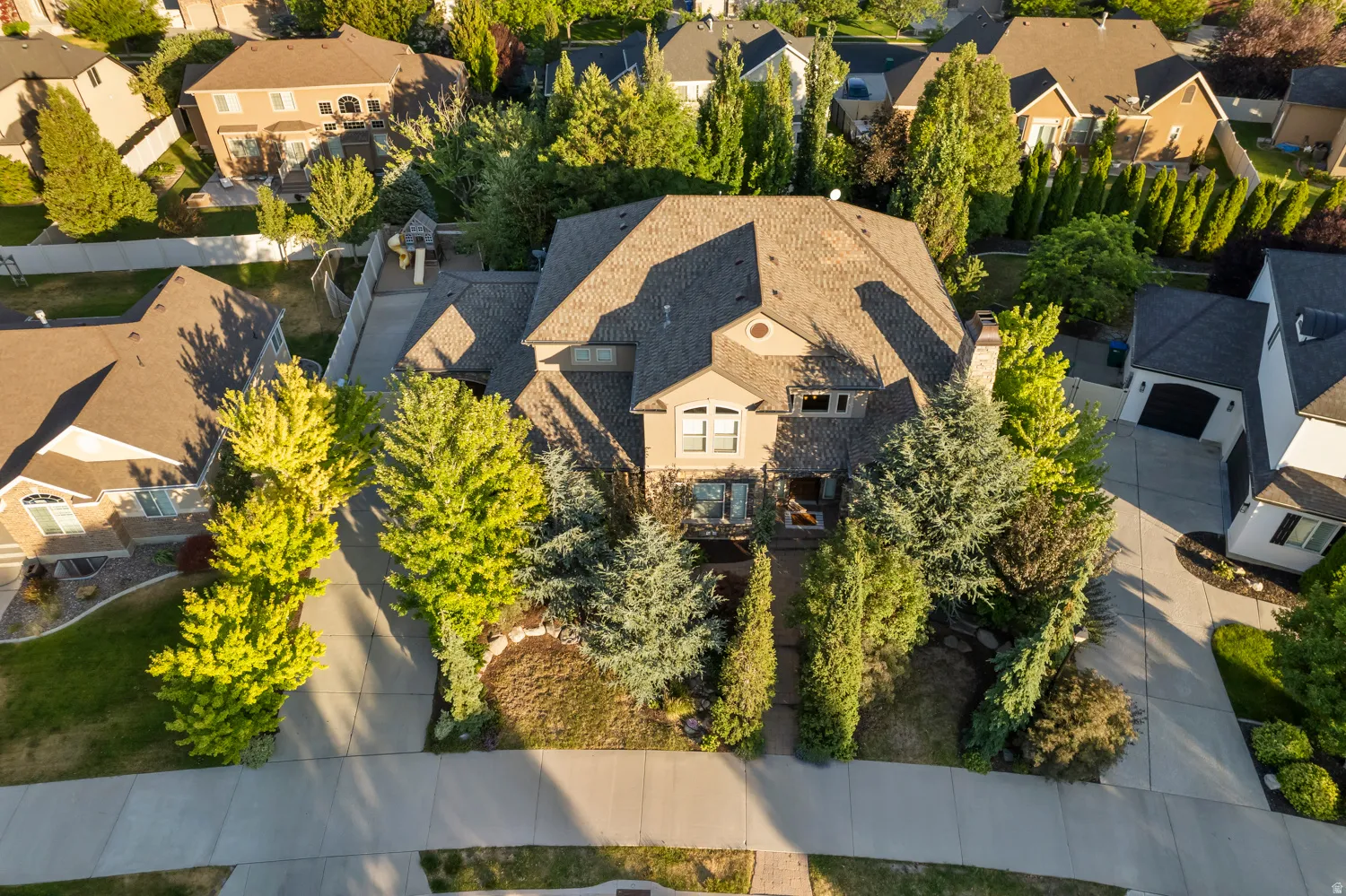 Multi-story residence featuring a shingle roof and stucco exterior