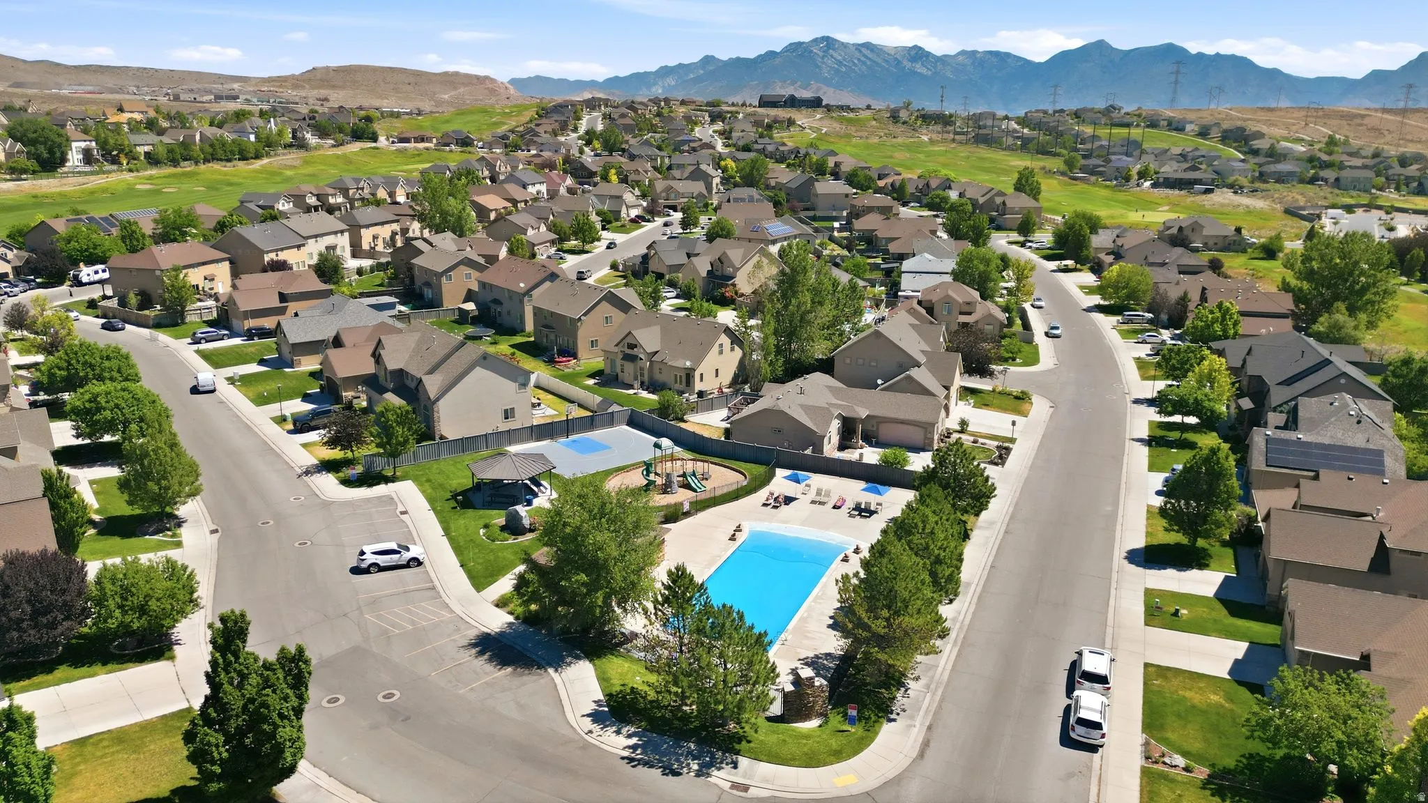 Residential community featuring an outdoor swimming pool, a playground area, and mature landscaping