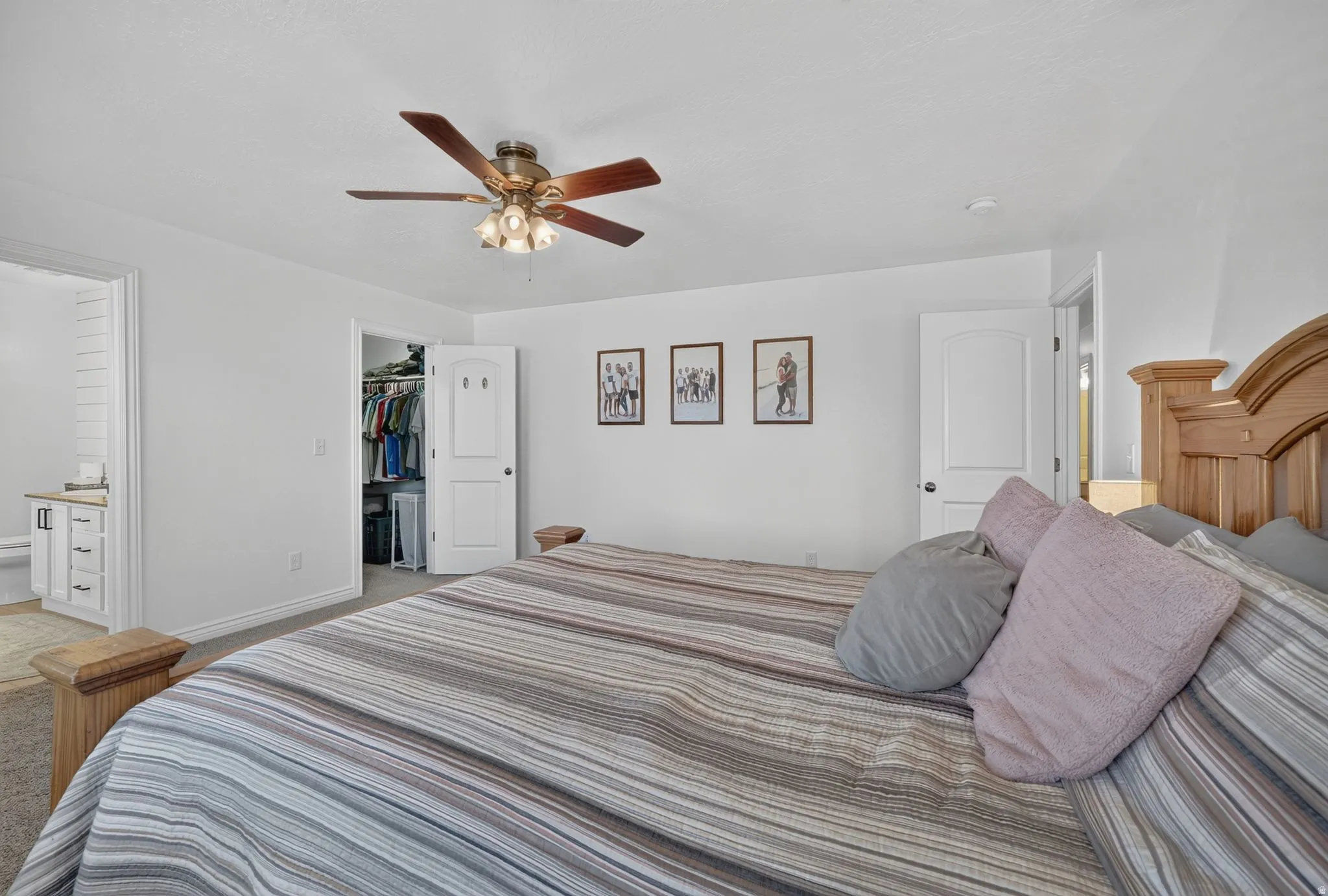 Bedroom featuring a ceiling fan with integrated lighting, a separate closet with an interior light, and carpet flooring