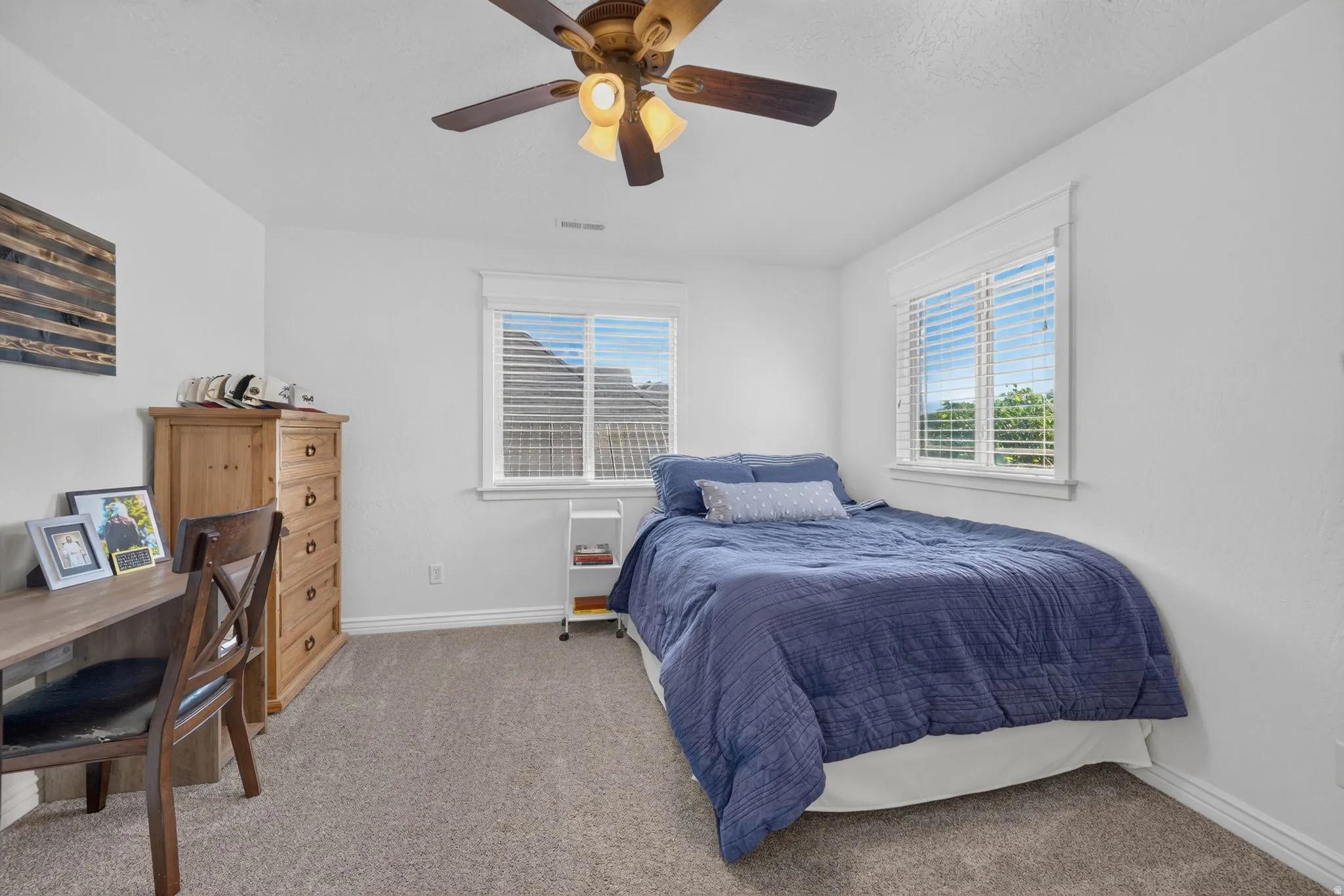 Neutral wall paint and carpeted flooring in a room featuring a window with white blinds and trim
