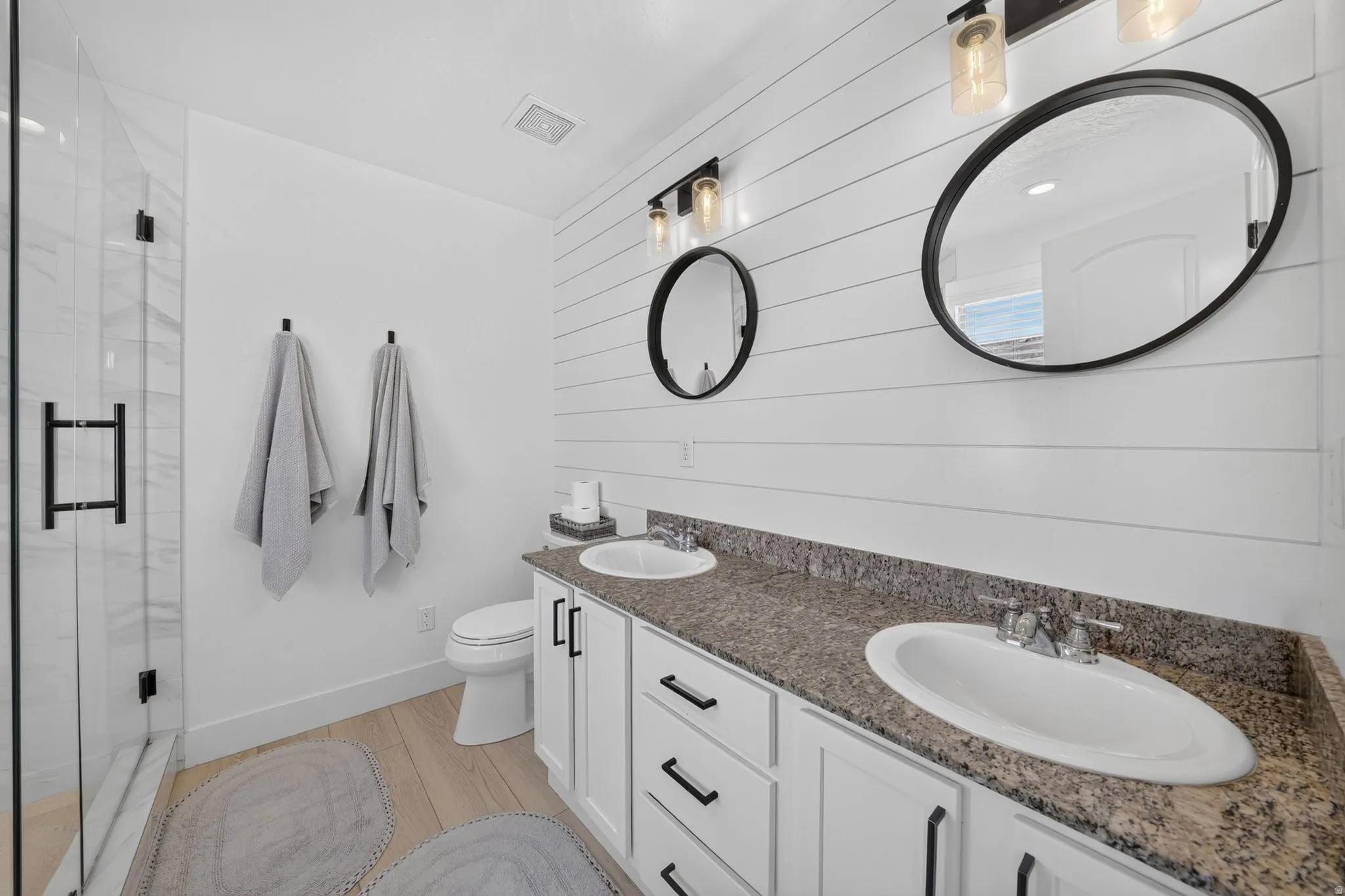 Dual vanity with stone-finish countertop and white cabinetry
