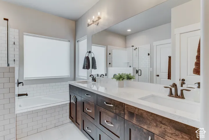 Double vanity featuring wood-finish cabinetry, white countertops, and bronze-finish fixtures