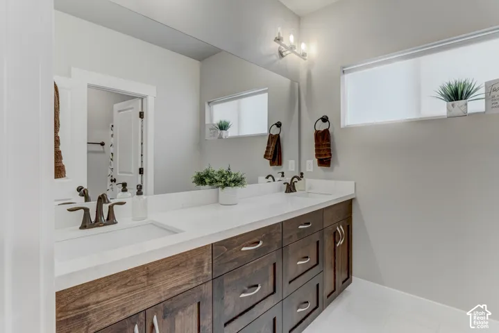 Dual vanity with dark wood-finish cabinetry, white countertops, and integrated rectangular sinks