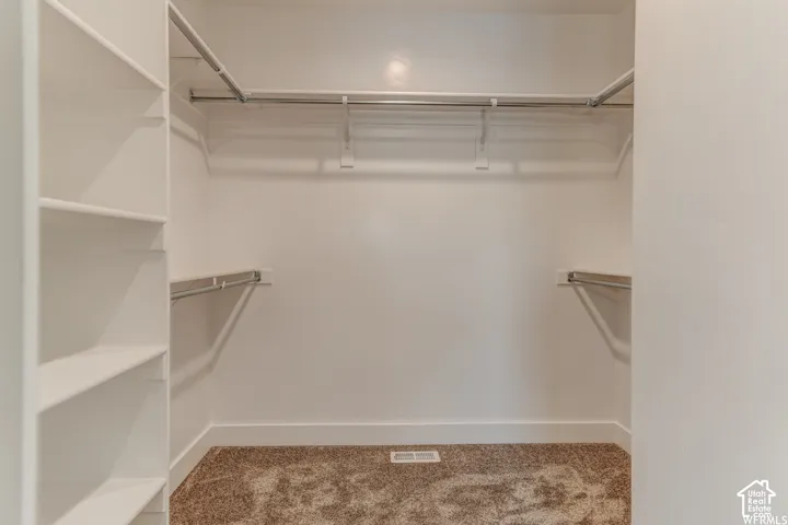 Built-in shelving, multiple hanging rods, and textured carpeting