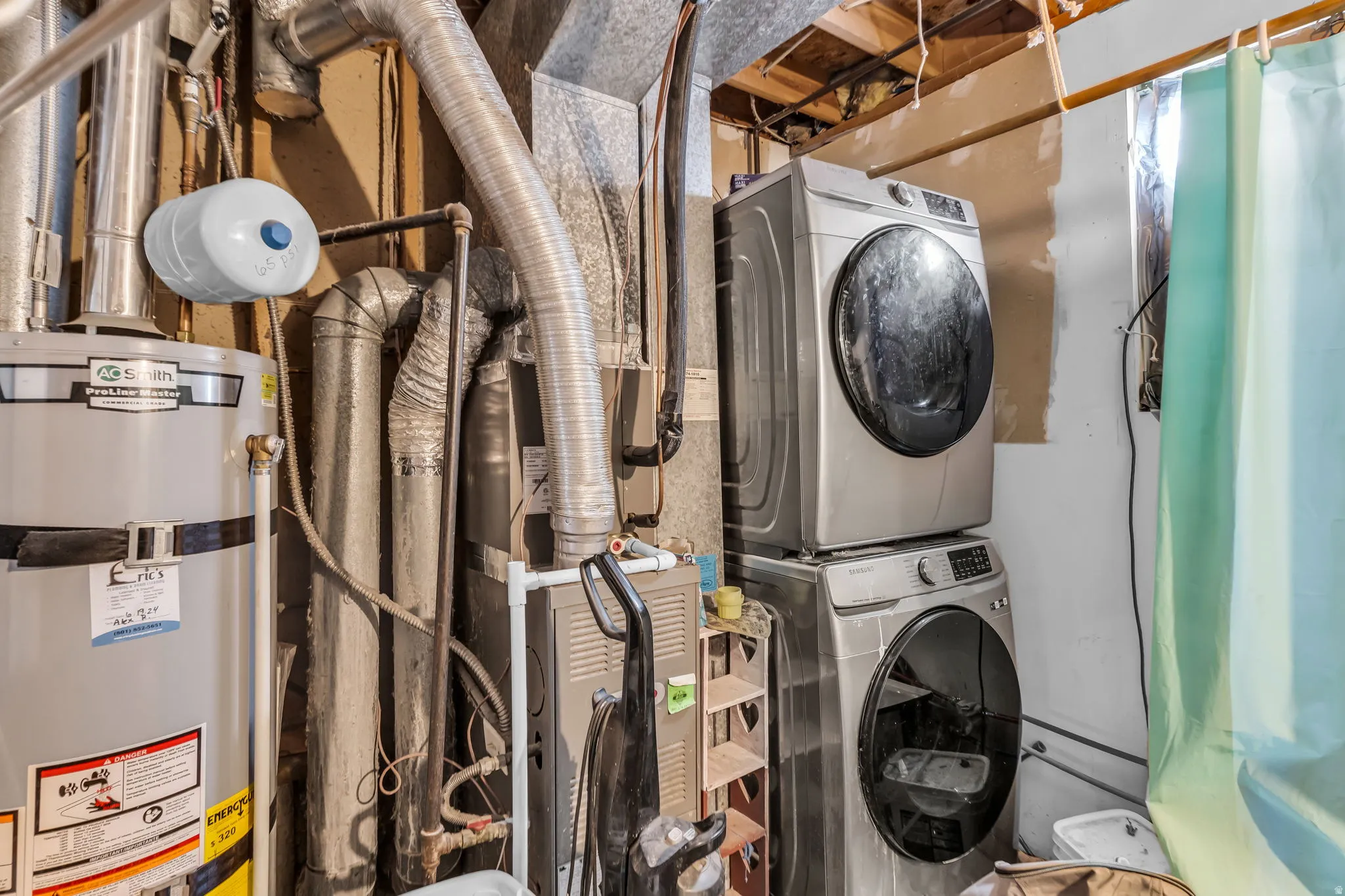 Utility area featuring a water heater, furnace, and exposed ductwork