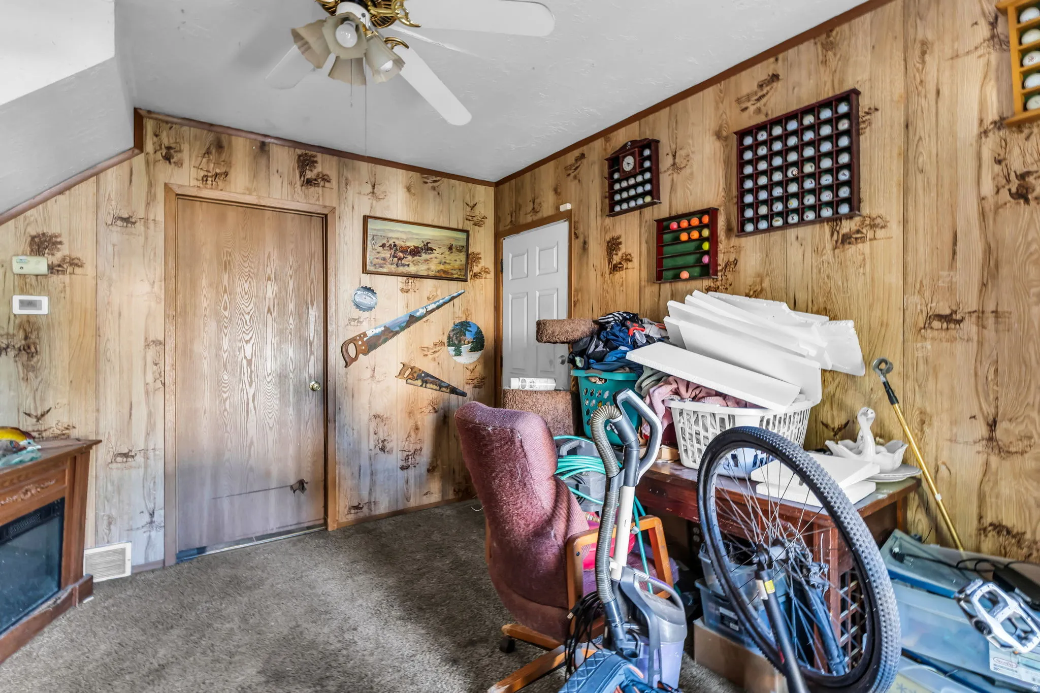 Room featuring wood-finish paneling, a ceiling fan with light fixture, and carpet flooring