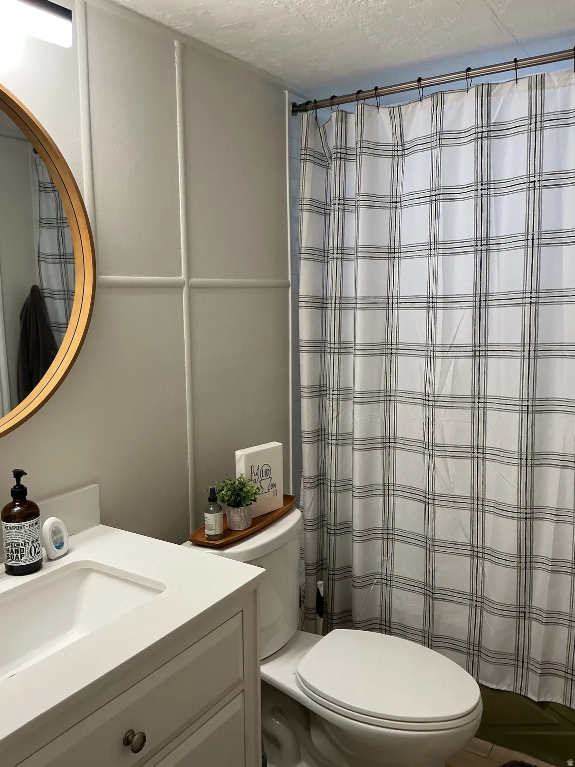 Bathroom vanity with an integrated sink, complementing a white toilet and a full-height paneled accent wall