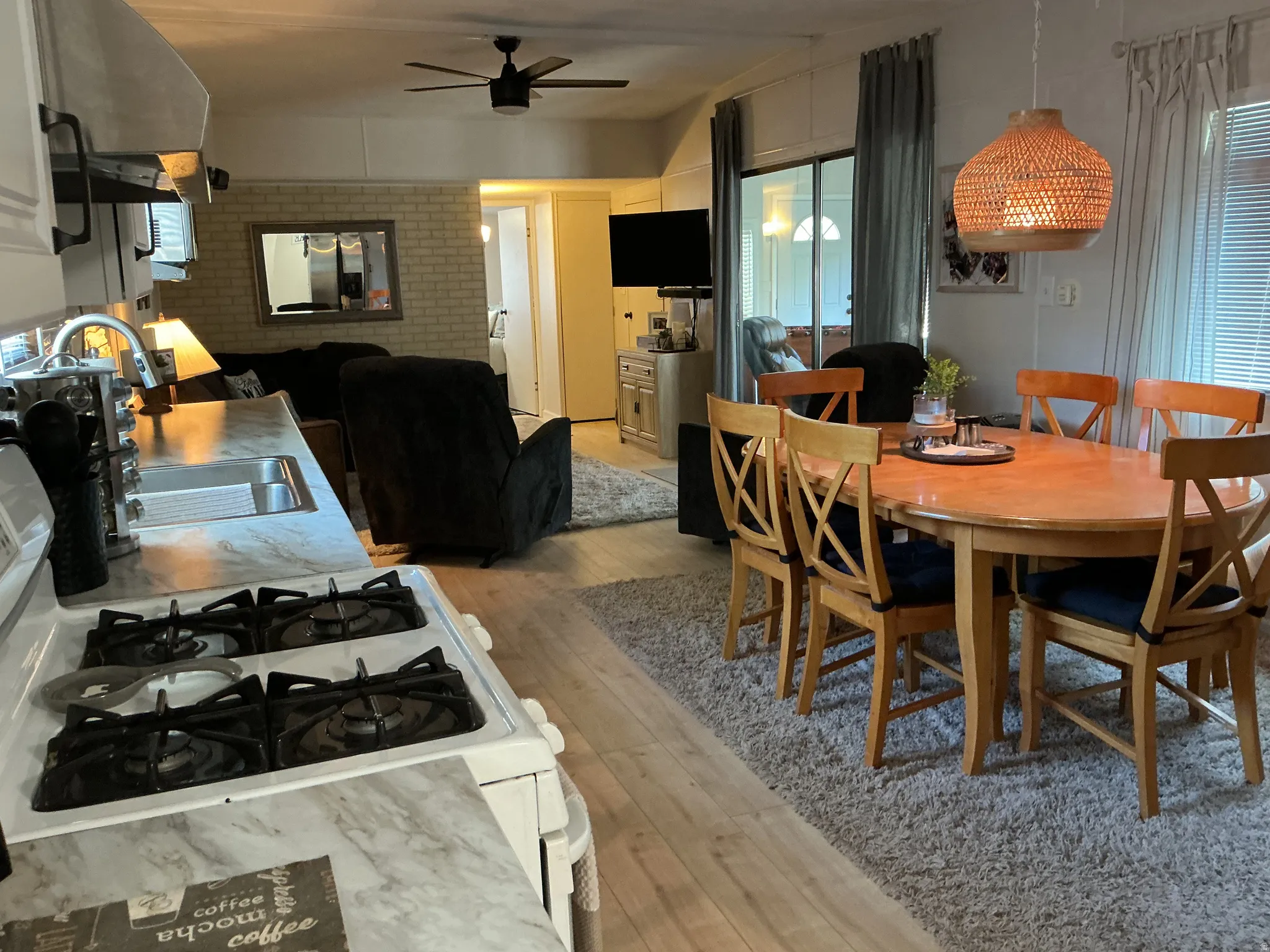 Full kitchen with a gas range, sink, and wood-finish flooring