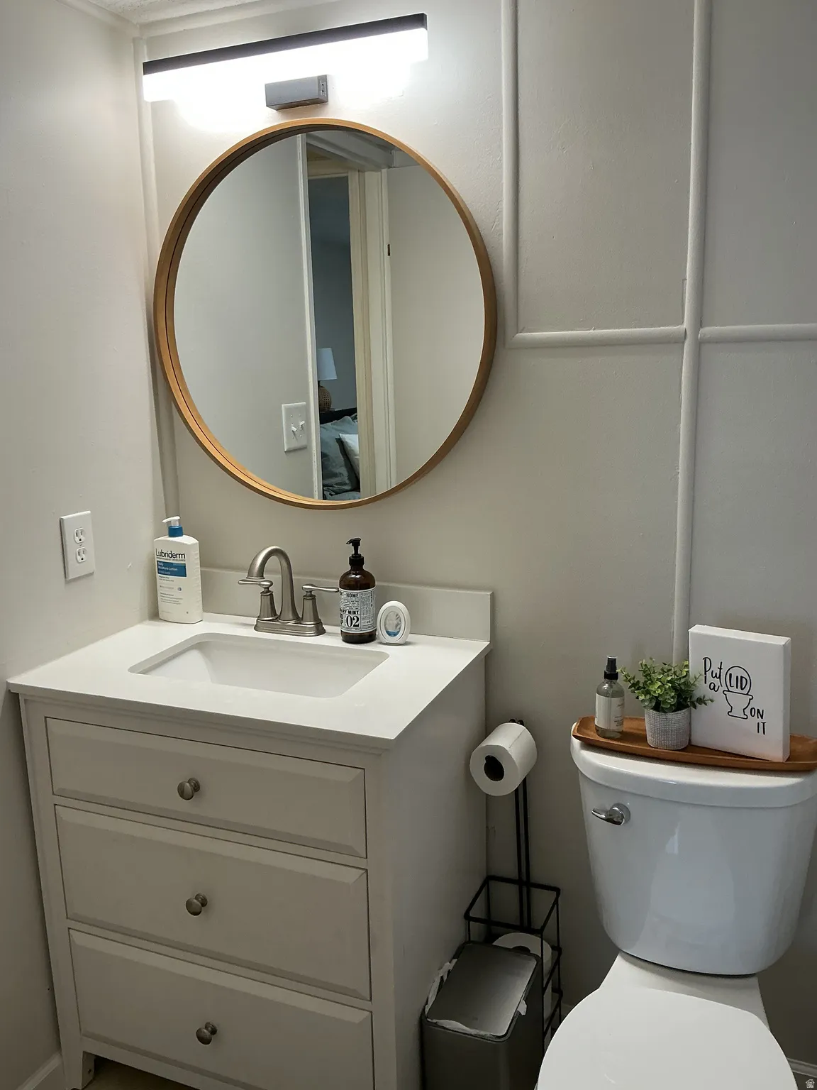 Bathroom featuring a white vanity with an integrated sink, brushed nickel faucet, and a light-colored countertop