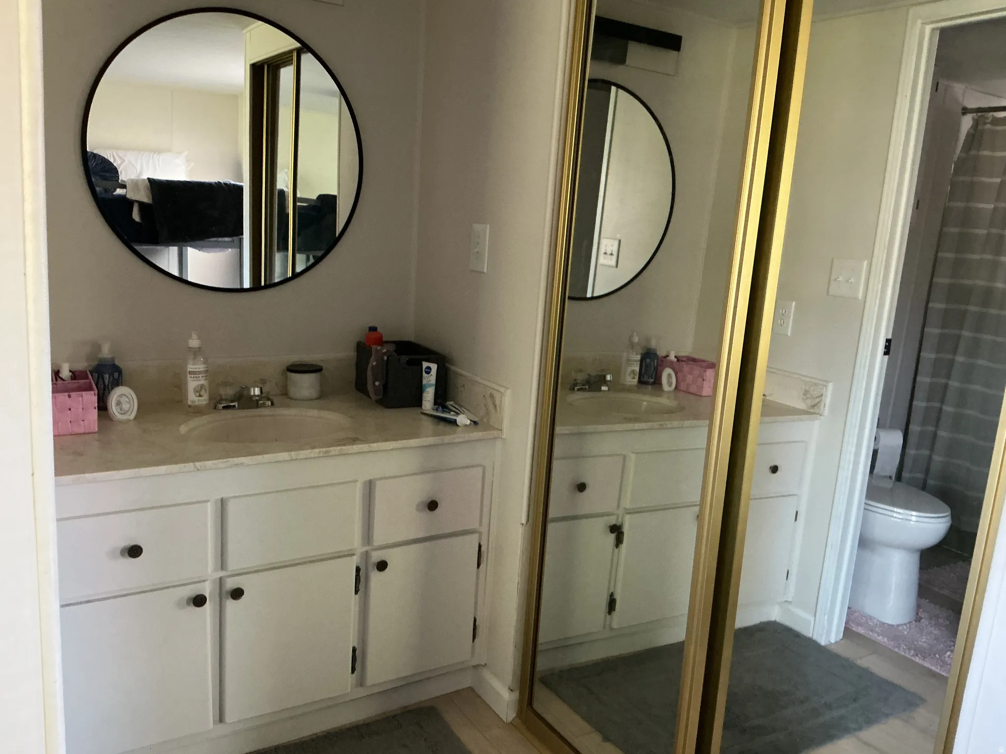 Bathroom vanity featuring a light-colored countertop, dual sinks, and white cabinetry