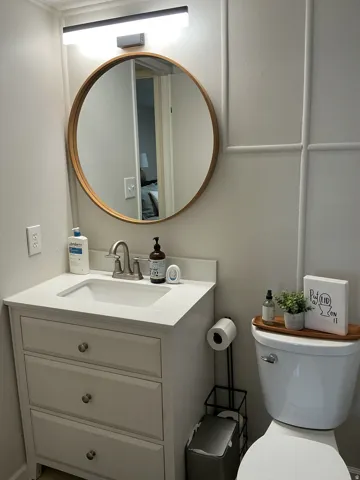 Bathroom featuring a white vanity with an integrated sink, brushed nickel faucet, and a light-colored countertop
