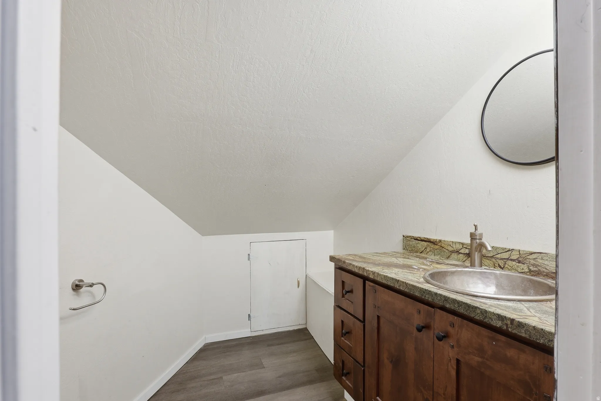 Vanity featuring a silver vessel sink, single-handle faucet, and patterned countertop