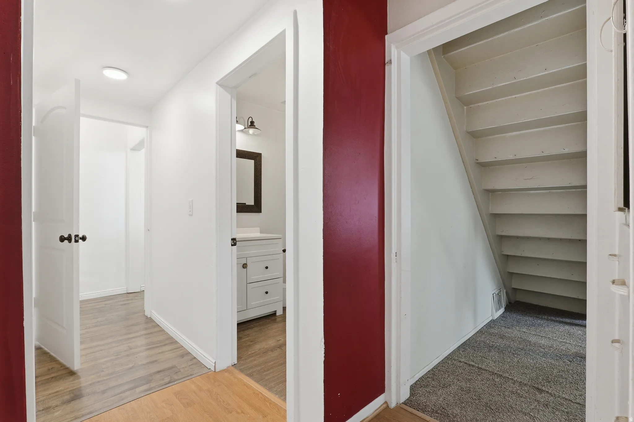 Hallway featuring wood-finish flooring and white paneled doors