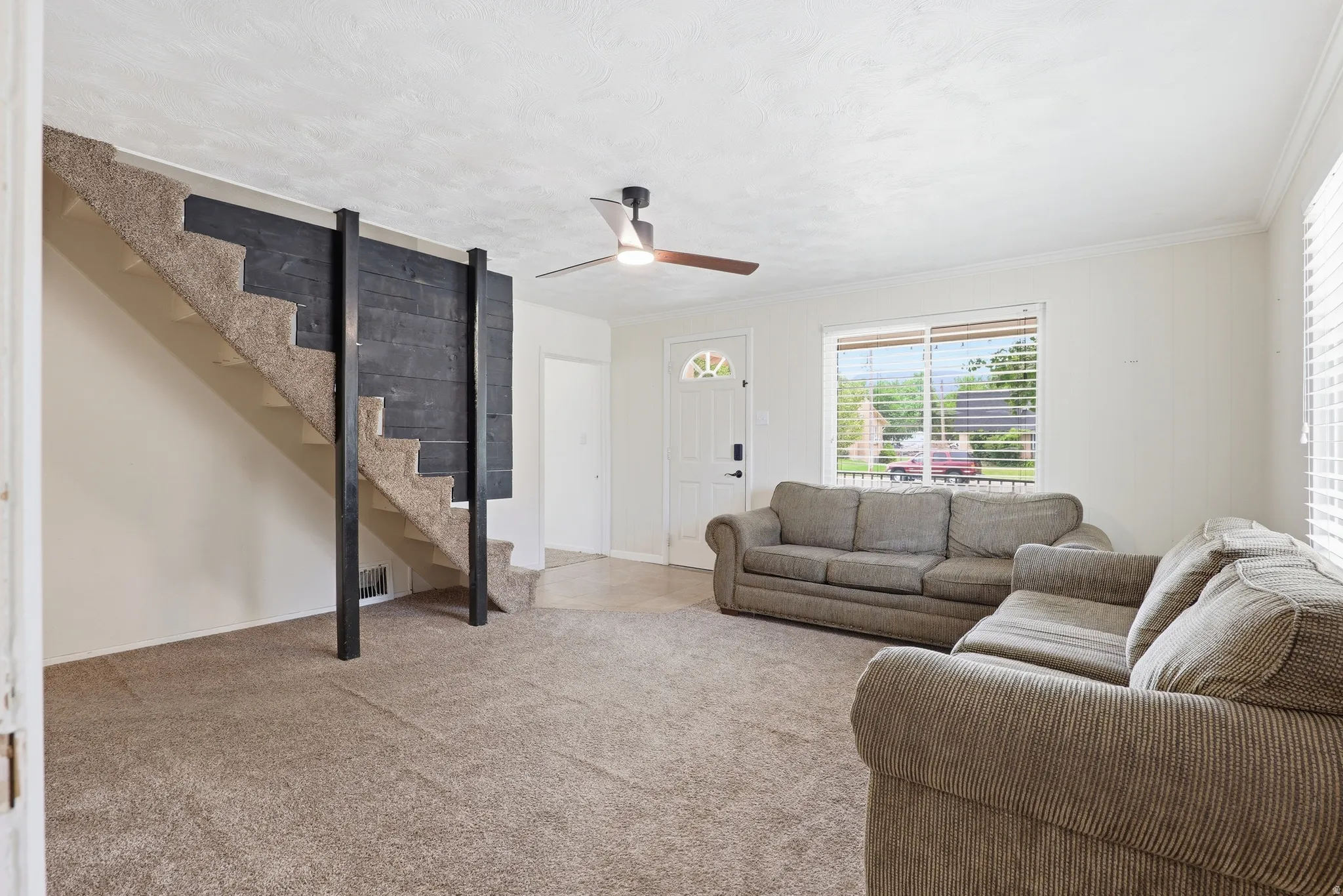 Carpeted staircase with dark wood-paneled accent wall