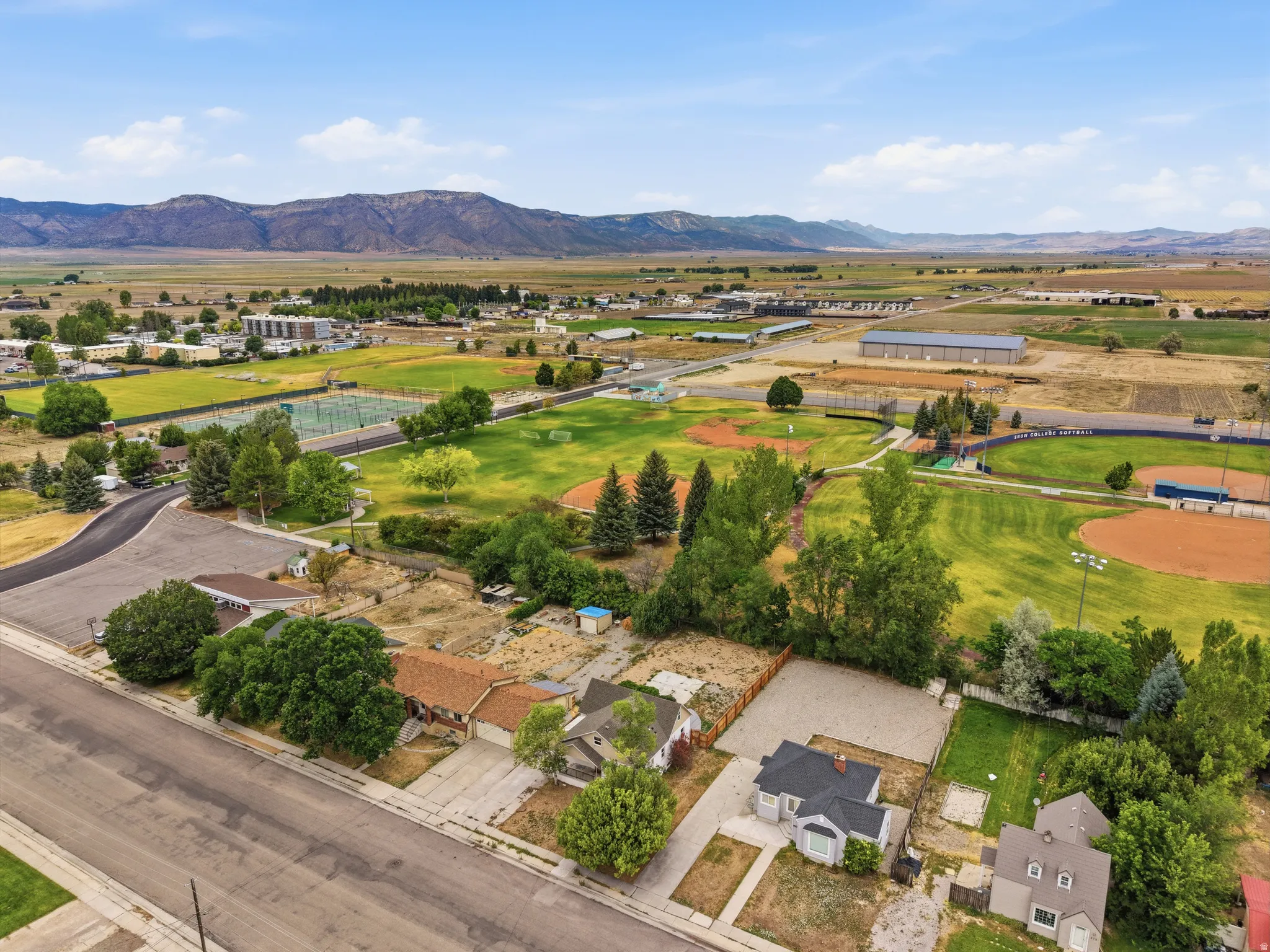 Aerial perspective showcasing residential properties near a community park with mountains in the background