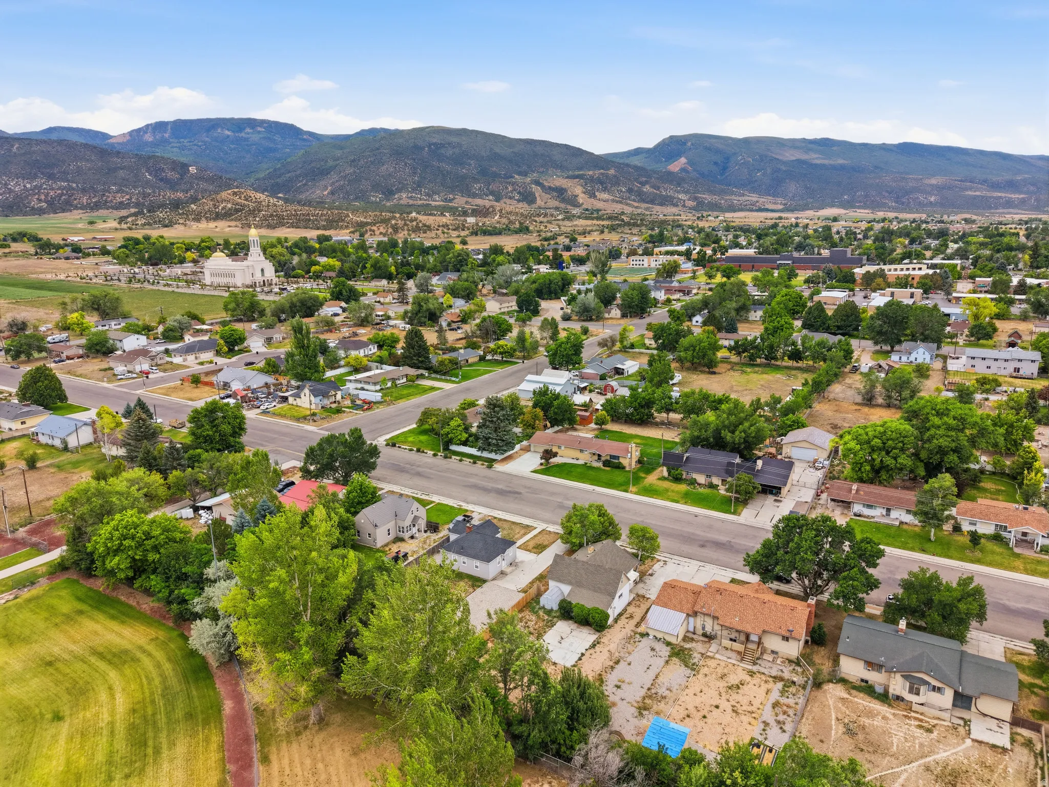 Expansive aerial perspective showcasing a residential neighborhood with surrounding mountainous terrain