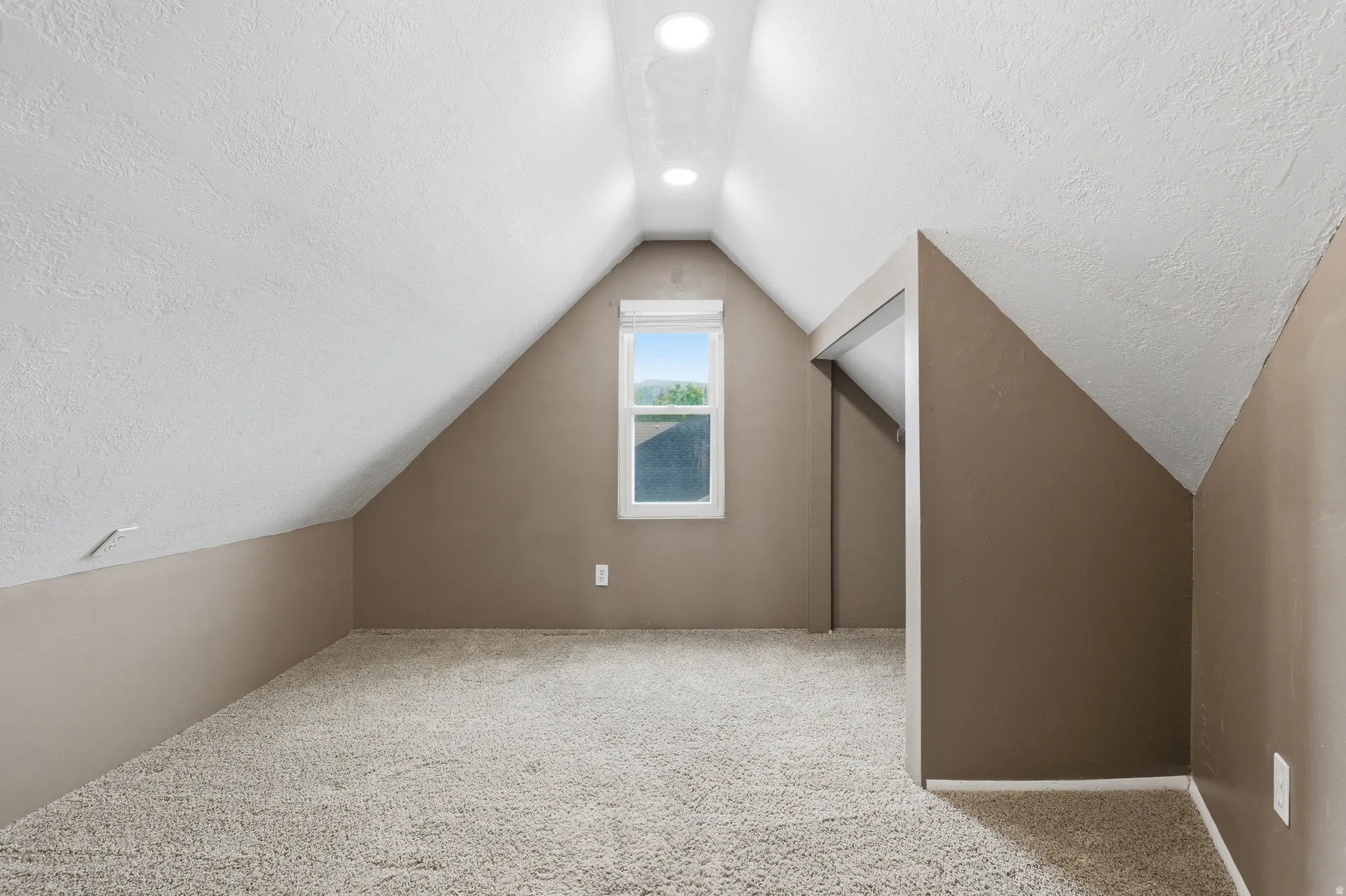 Carpeted room featuring a single window, recessed lighting, and sloped ceilings