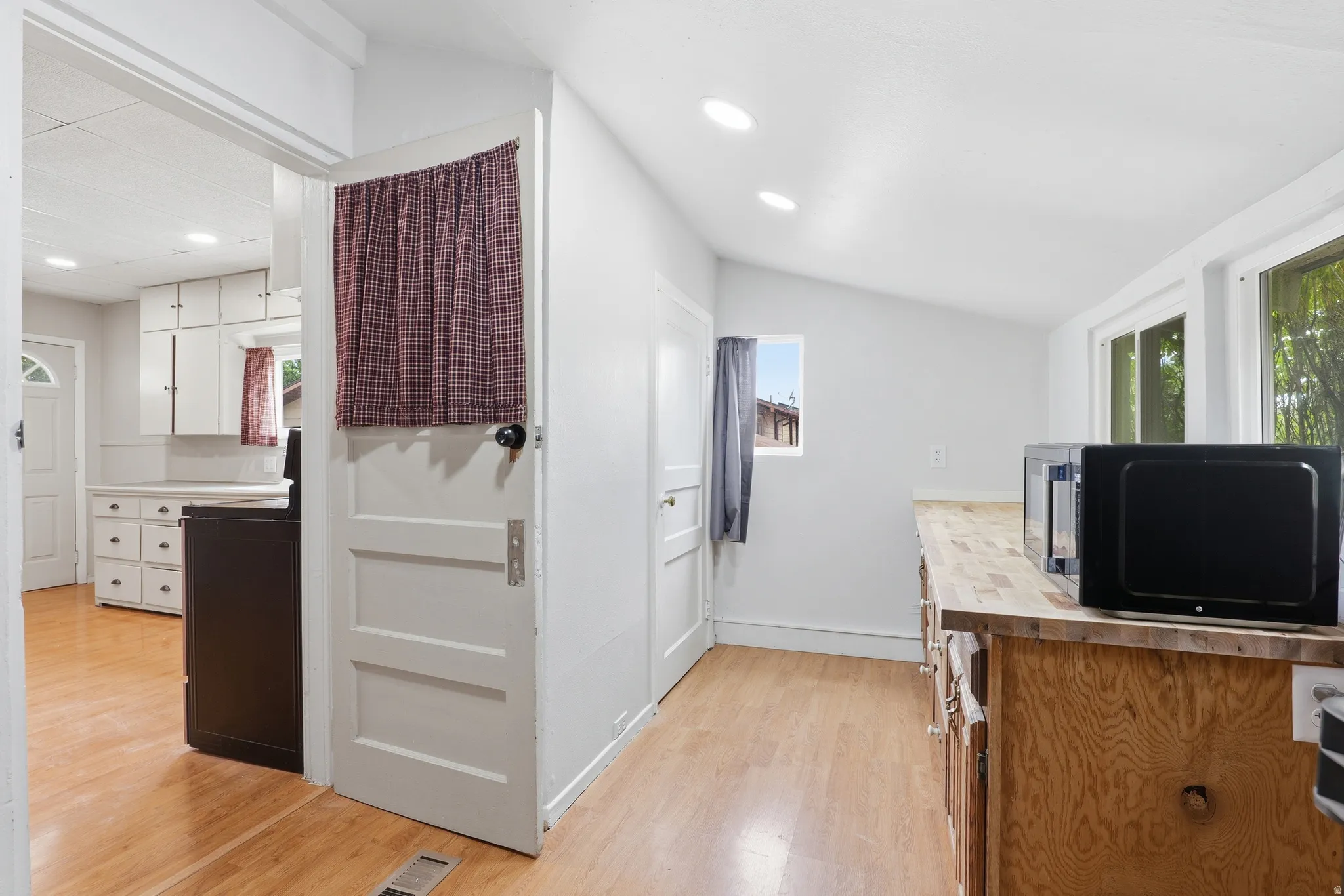 Kitchen area featuring light wood-finish flooring, white cabinetry, and recessed lighting