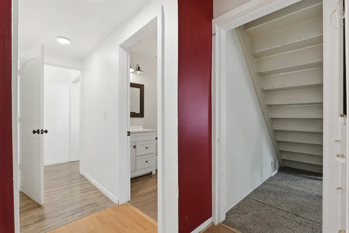 Hallway featuring wood-finish flooring and white paneled doors