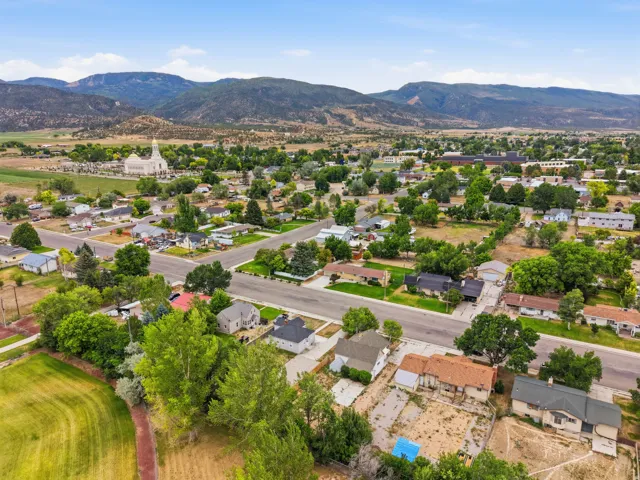 Expansive aerial perspective showcasing a residential neighborhood with surrounding mountainous terrain