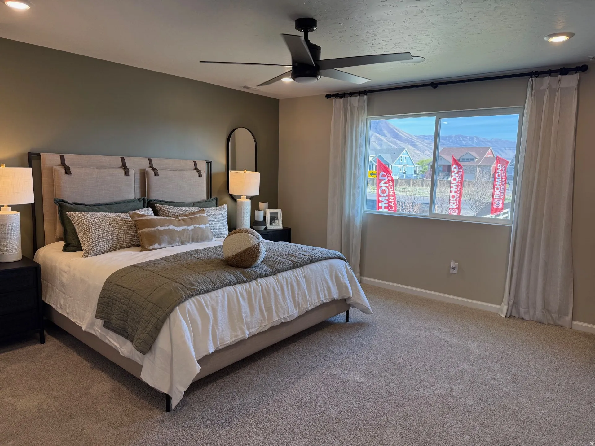 Spacious Primary bedroom featuring neutral carpeting, a large window, recessed lighting, a ceiling fan, and painted walls