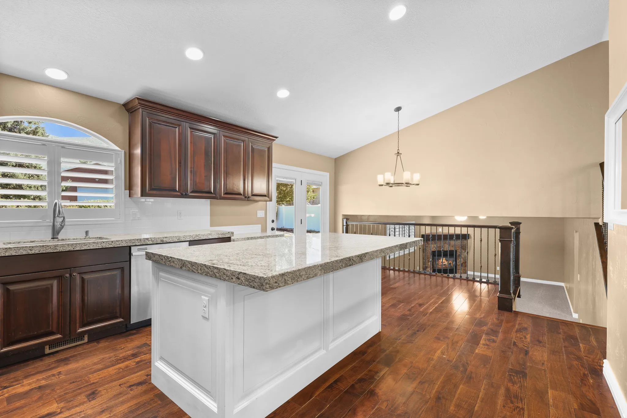 Kitchen featuring a white island with a stone countertop, dark wood-finish cabinetry, a subway tile backsplash, and recessed lighting