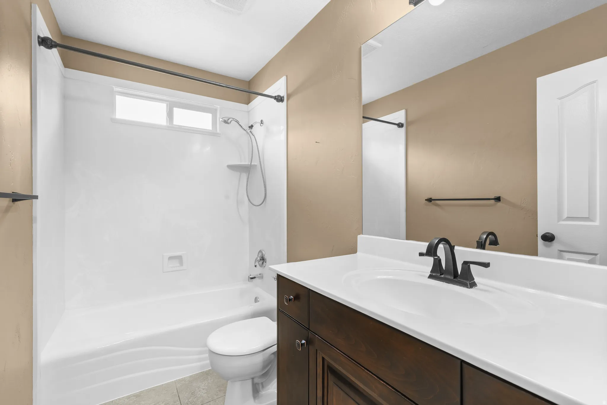 Full Bathroom featuring a dark wood-finish vanity with a white countertop and integrated sink, tile flooring