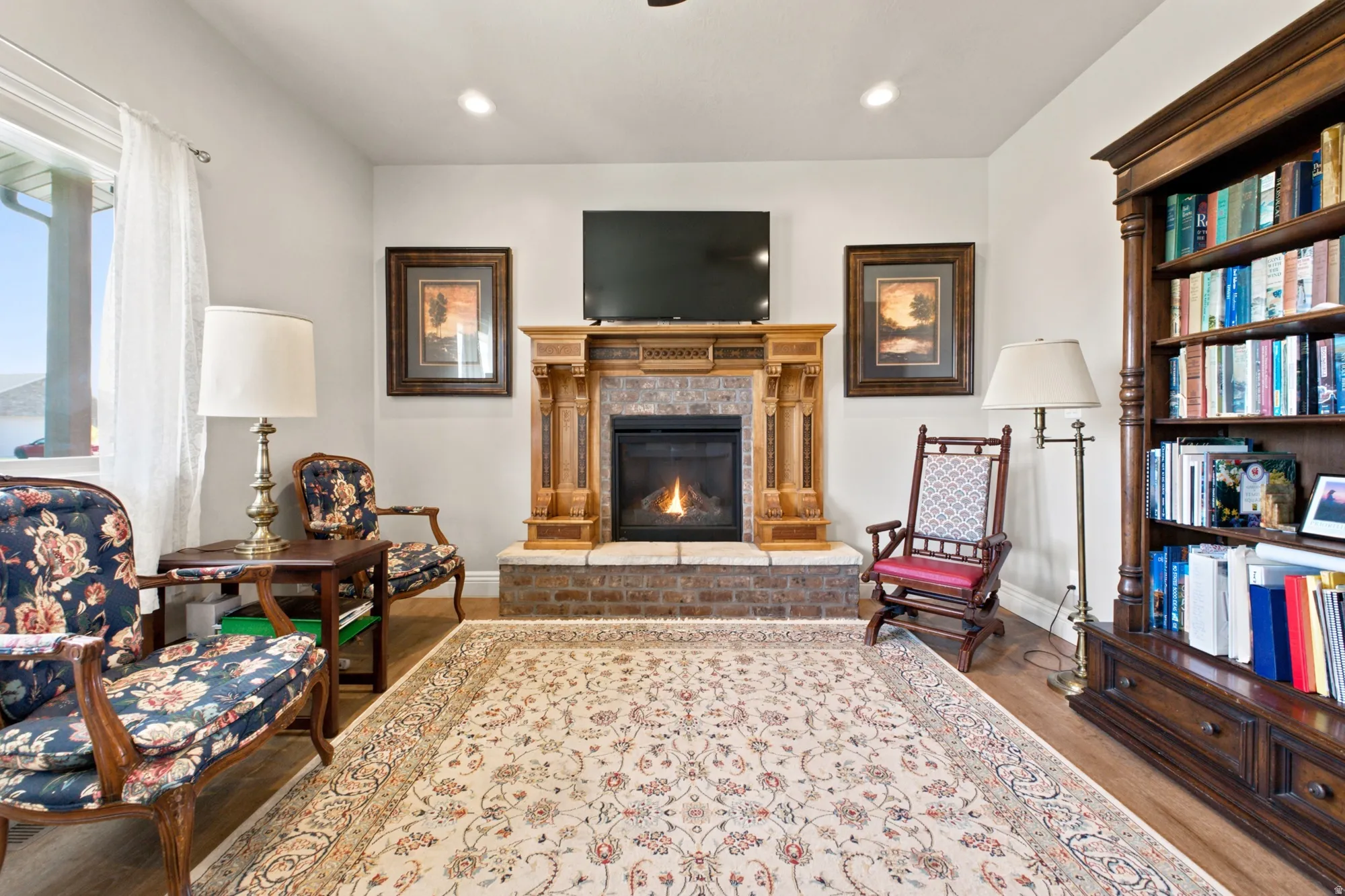 Living area featuring a central fireplace with a wood mantel and tile surround