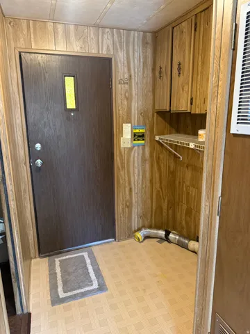 Entryway featuring wood-look wall paneling and patterned vinyl flooring
