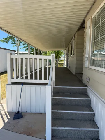 Covered porch with white railings and vertical siding accents