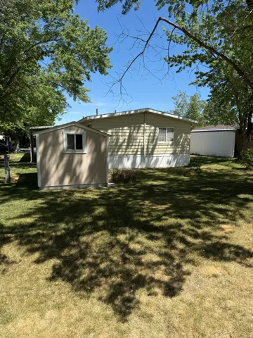 Rear exterior with tan horizontal siding and white trim