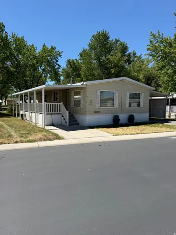 Single-story residence featuring light-colored siding and a covered front porch with white railings