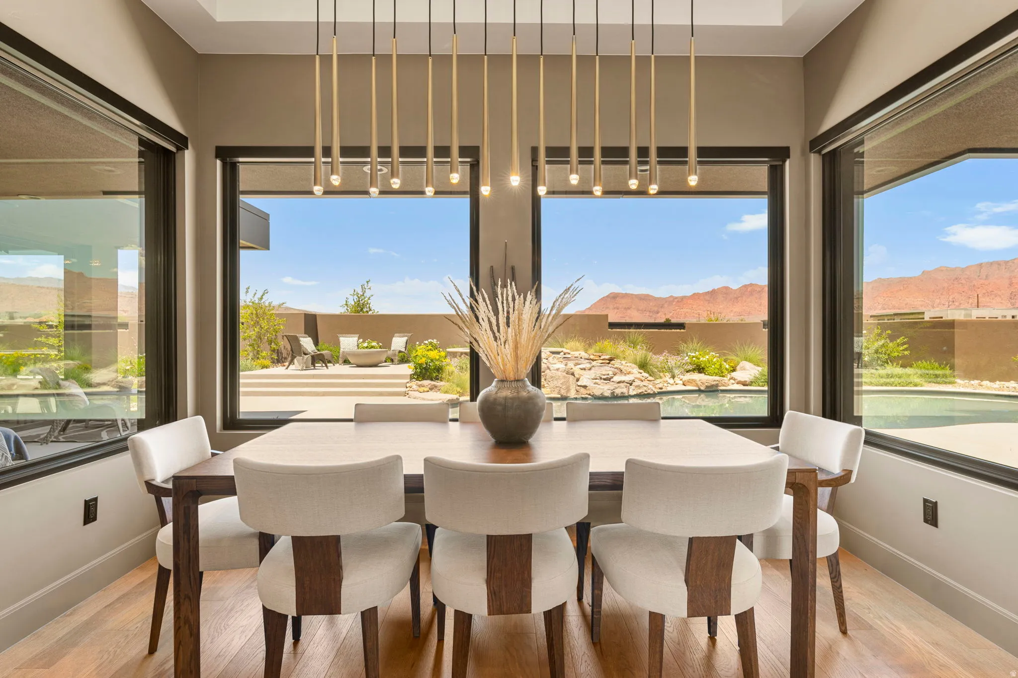 Dining area featuring large picture windows, wood-finish flooring, and a multi-pendant linear light fixture