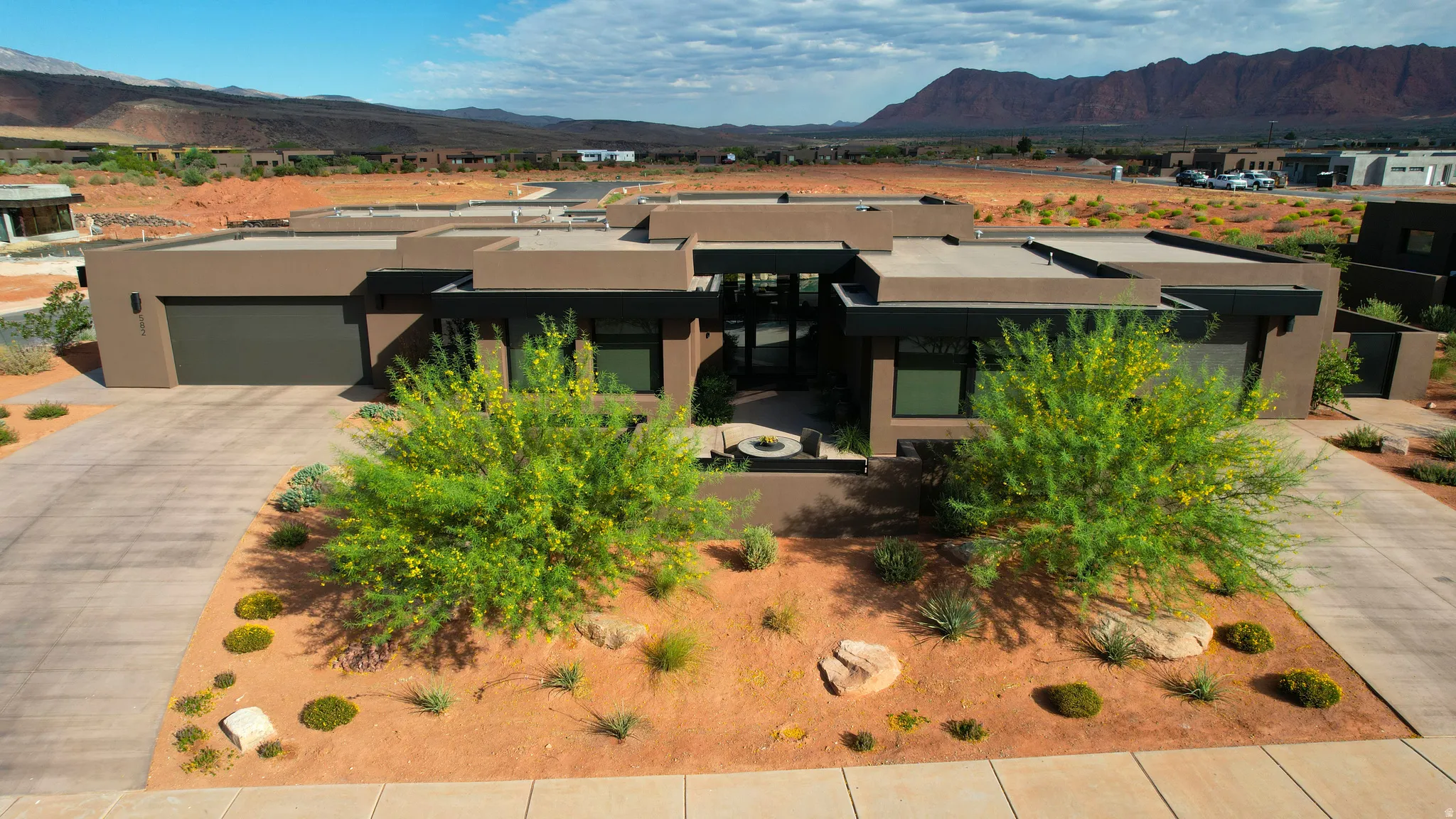 Contemporary flat-roof residence featuring an integrated garage and a desert-inspired landscape