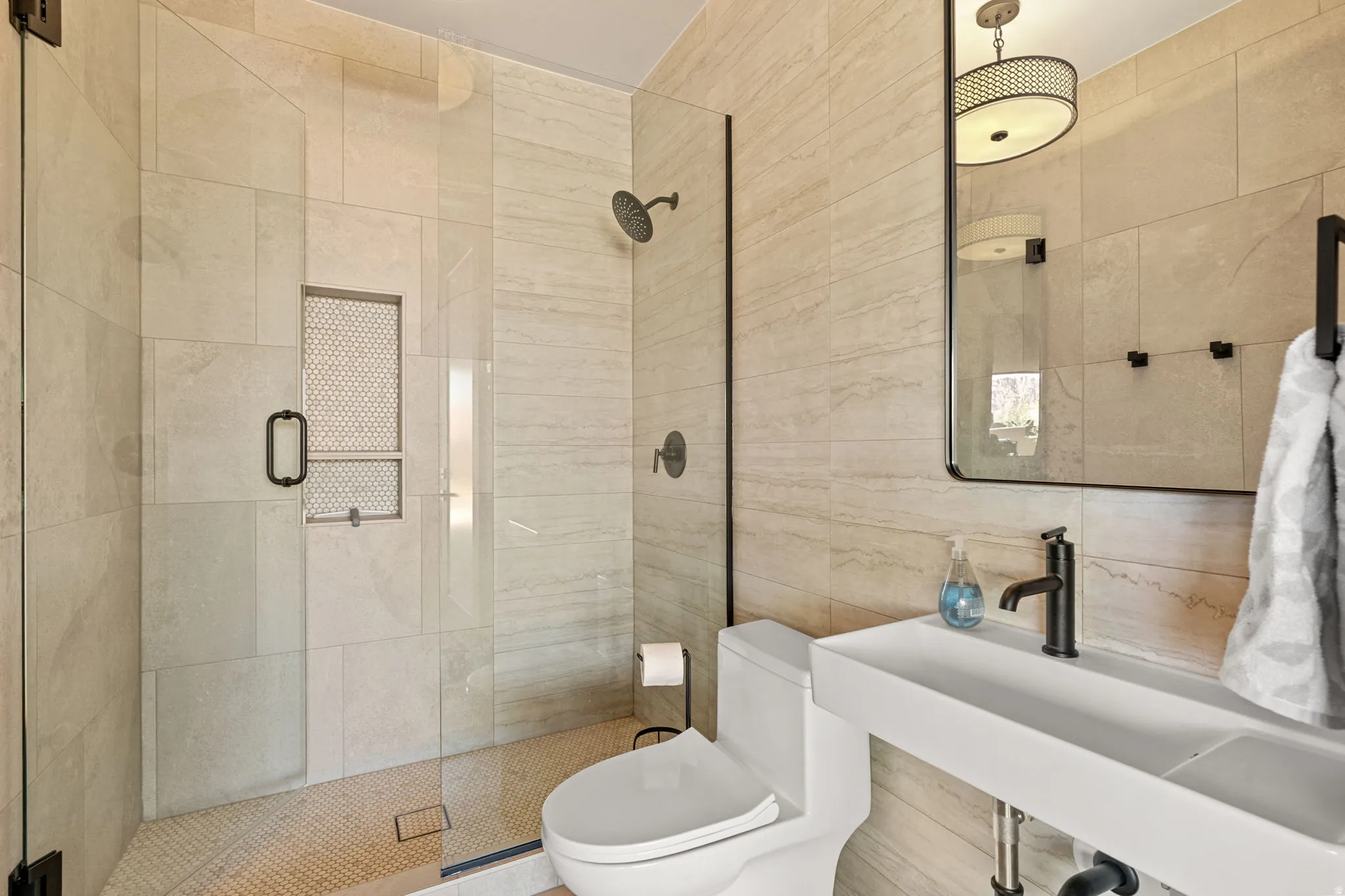 Outside pool area bathroom featuring a walk-in shower with clear glass enclosure and built-in shelving