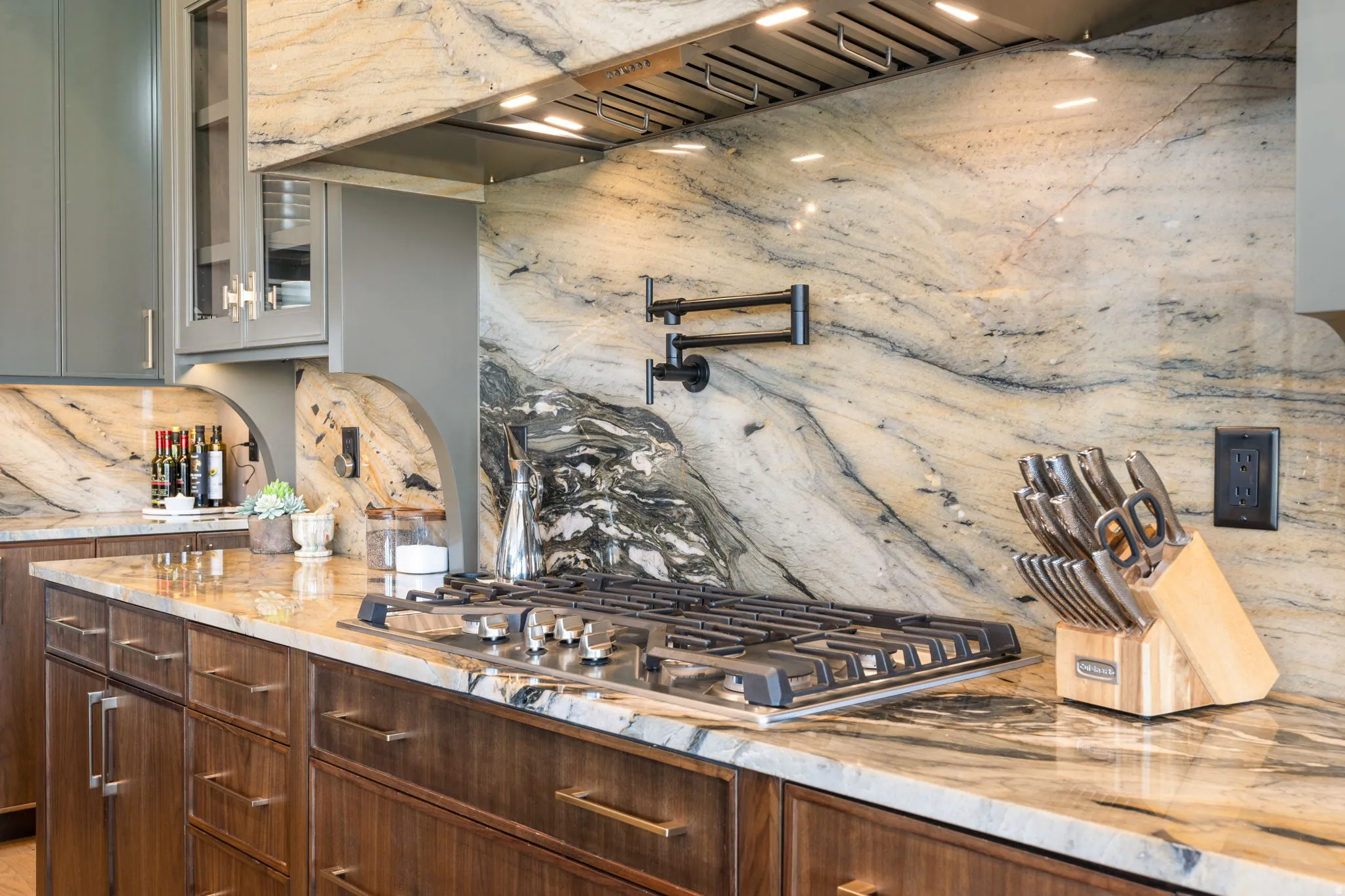 Gourmet kitchen featuring a stainless steel gas range, a pot filler, and a professional-grade range hood