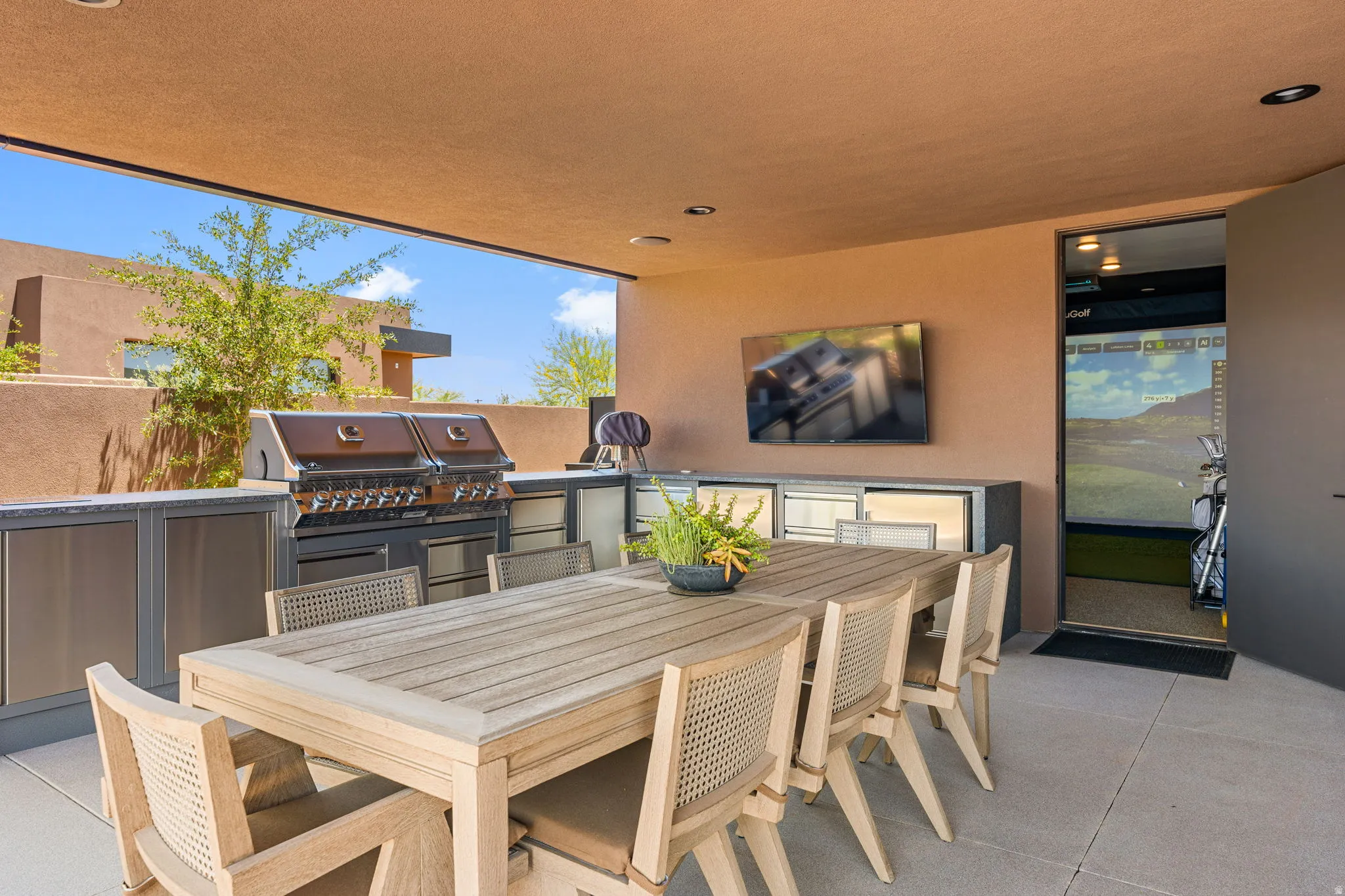 Covered outdoor patio featuring a built-in barbecue grill, extensive counter space, and integrated cabinetry