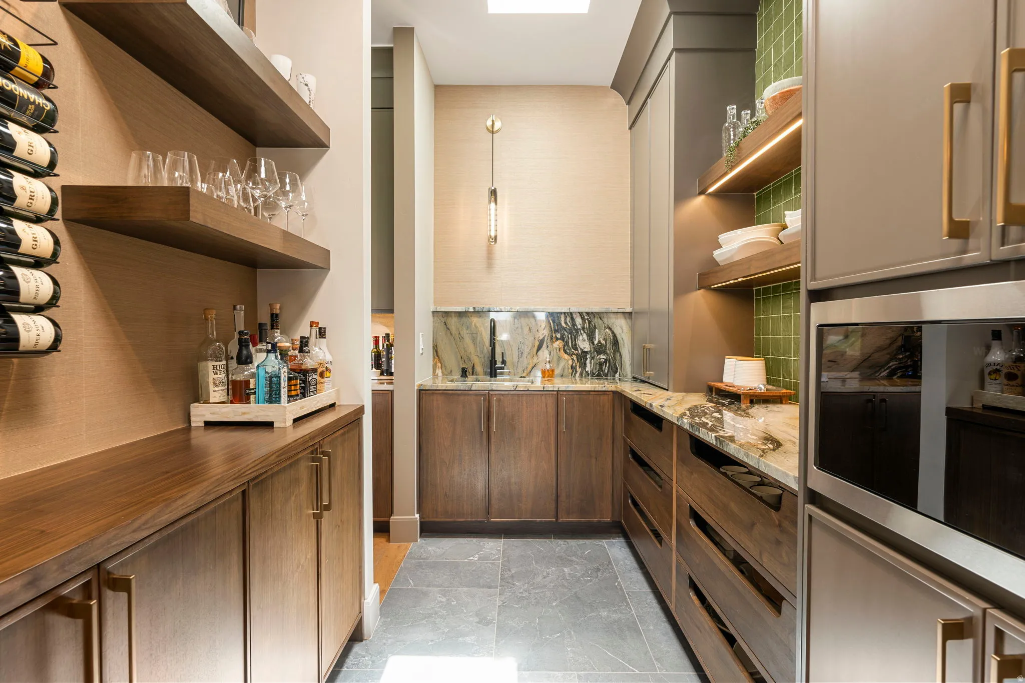 Custom bar area featuring built-in cabinetry, floating shelves, quartzite countertops, and integrated appliances