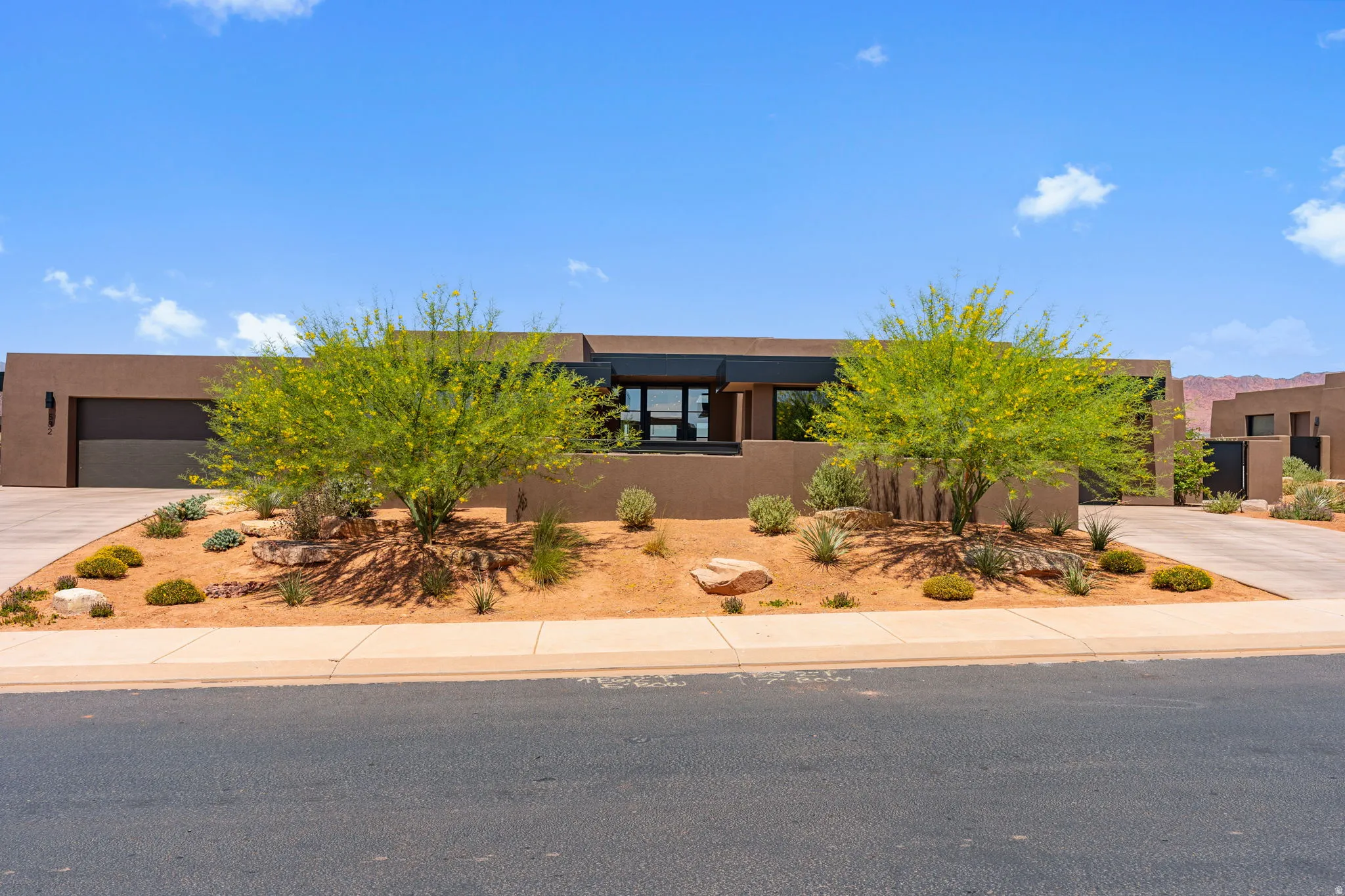 Contemporary facade with a flat roofline, stucco exterior, and integrated garage