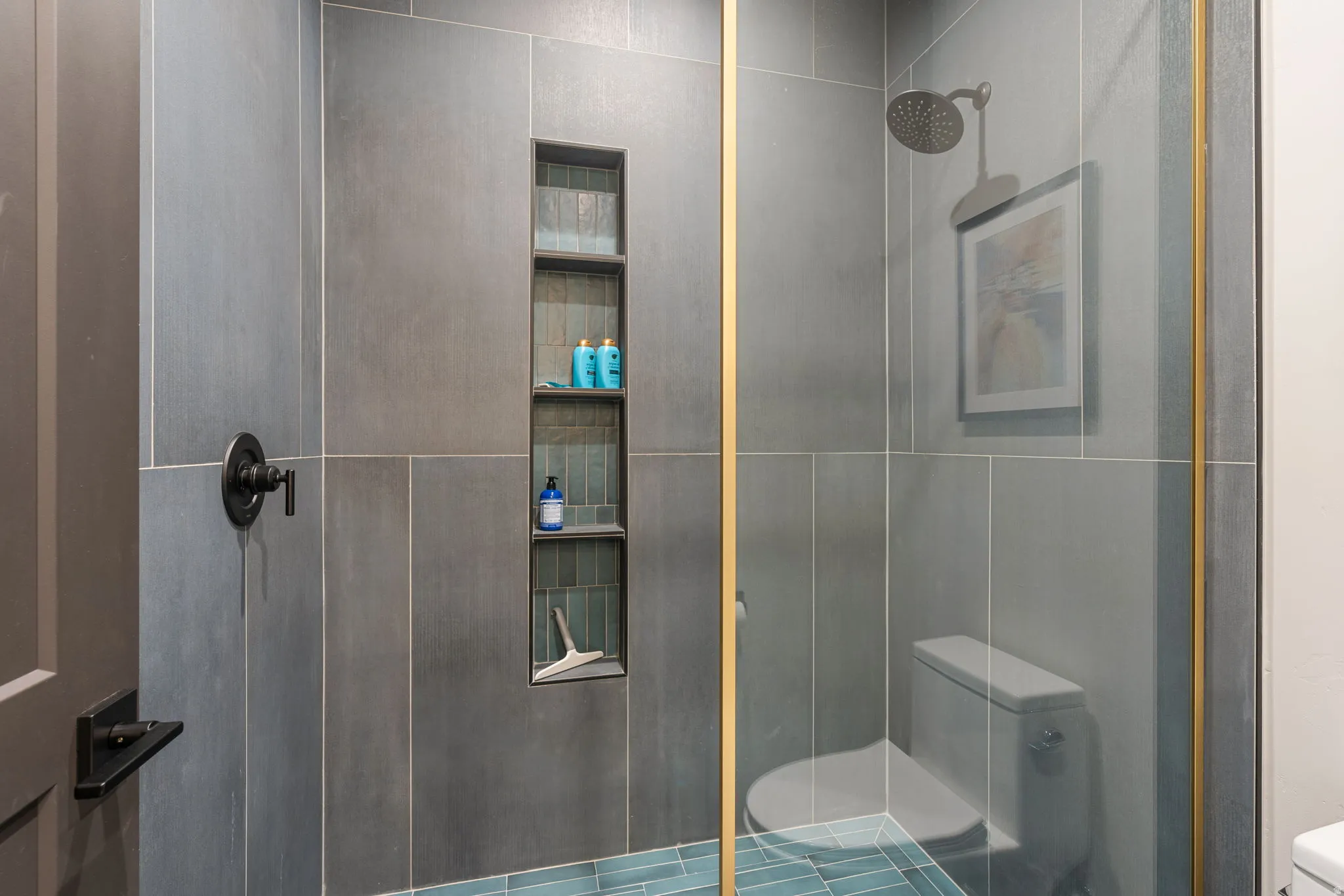 Glass-enclosed shower with large format wall tiles
