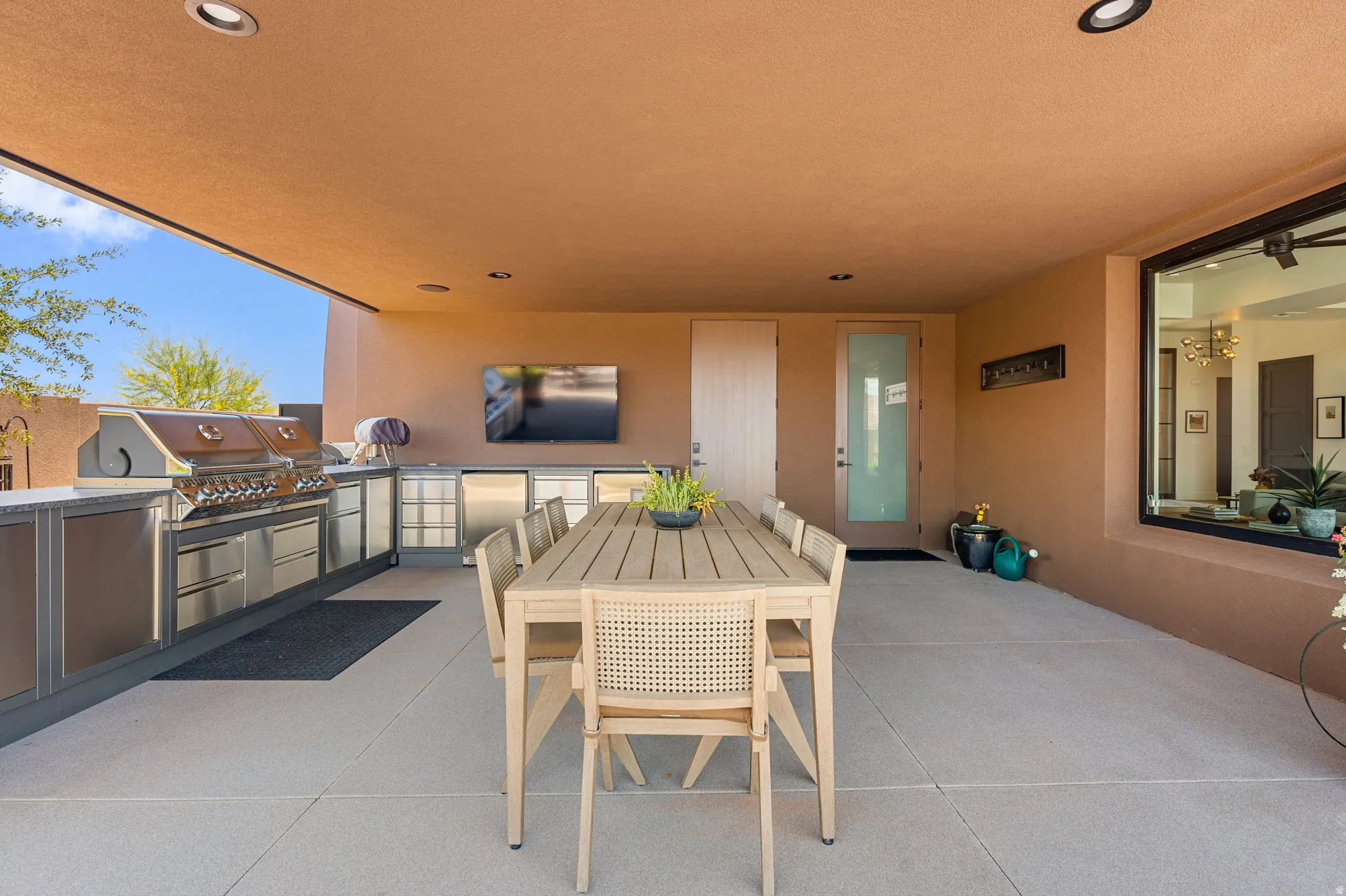 Covered patio featuring an outdoor kitchen with stainless steel appliances, built-in cabinetry, and integrated grill