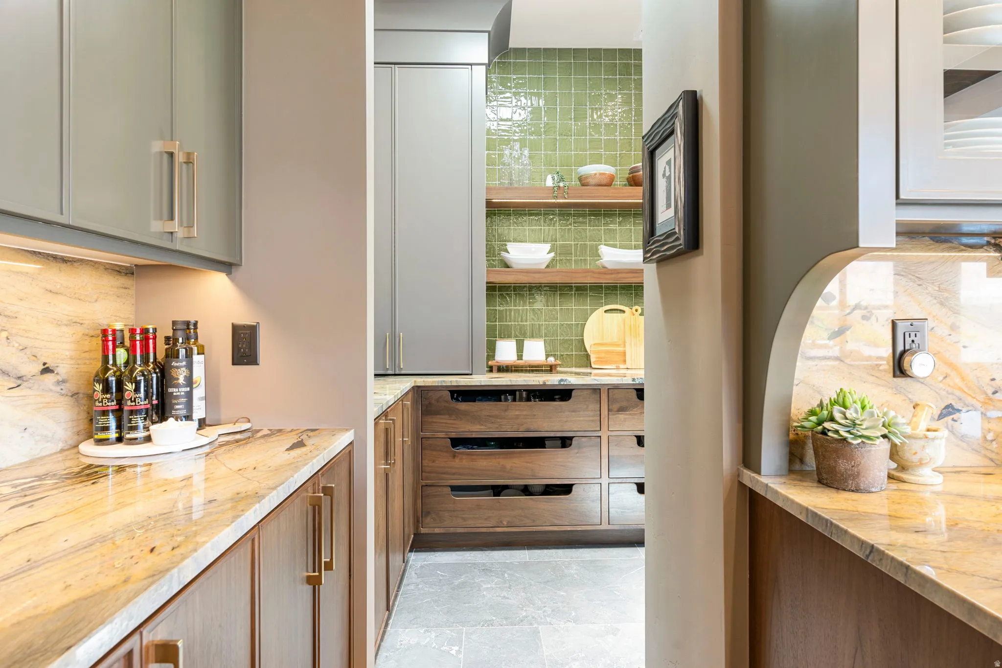 Kitchenette area featuring painted upper cabinetry, wood lower cabinetry, and quartzite countertops