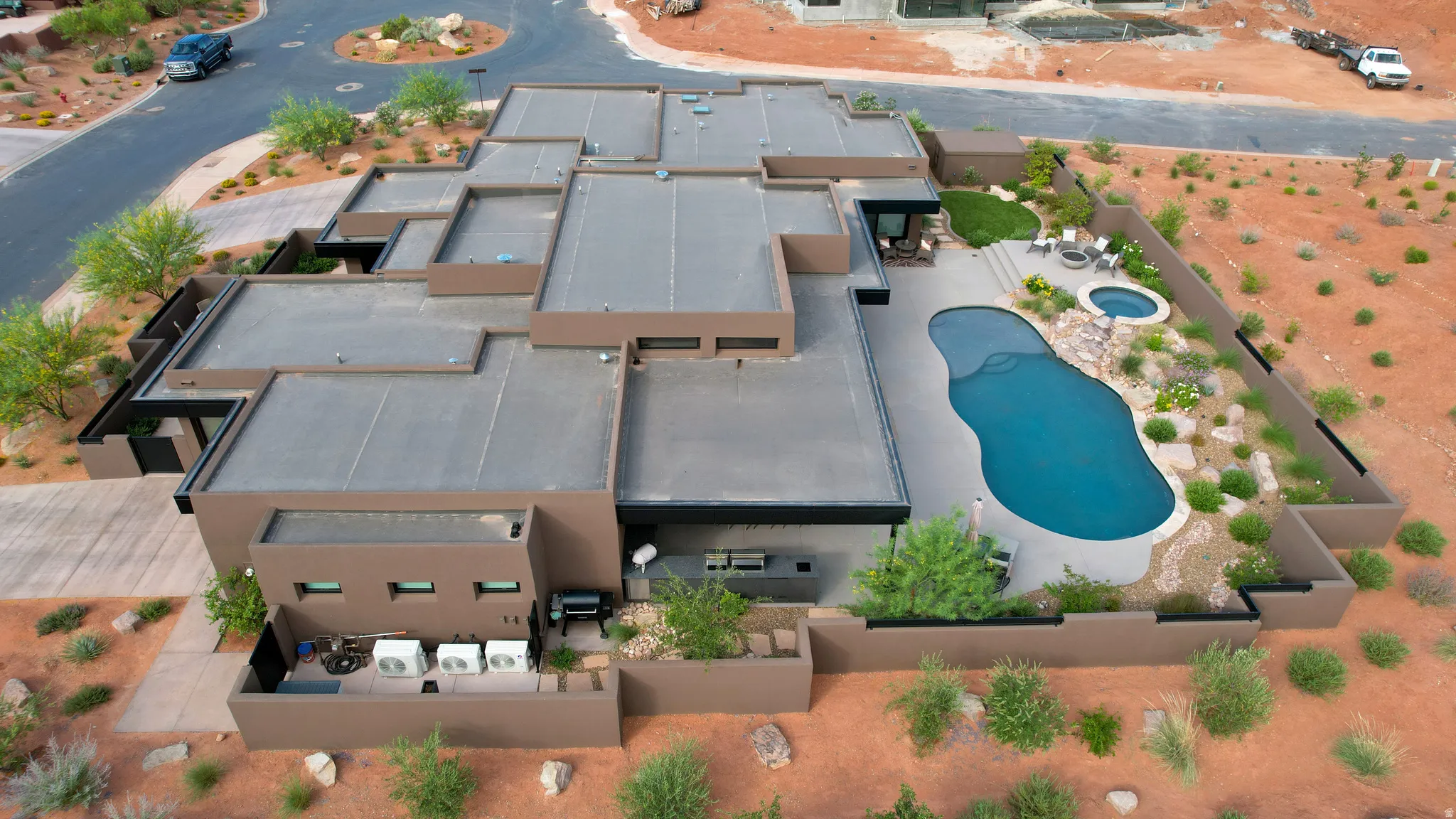 Modern desert residence featuring a freeform swimming pool, integrated spa, and an expansive paved patio
