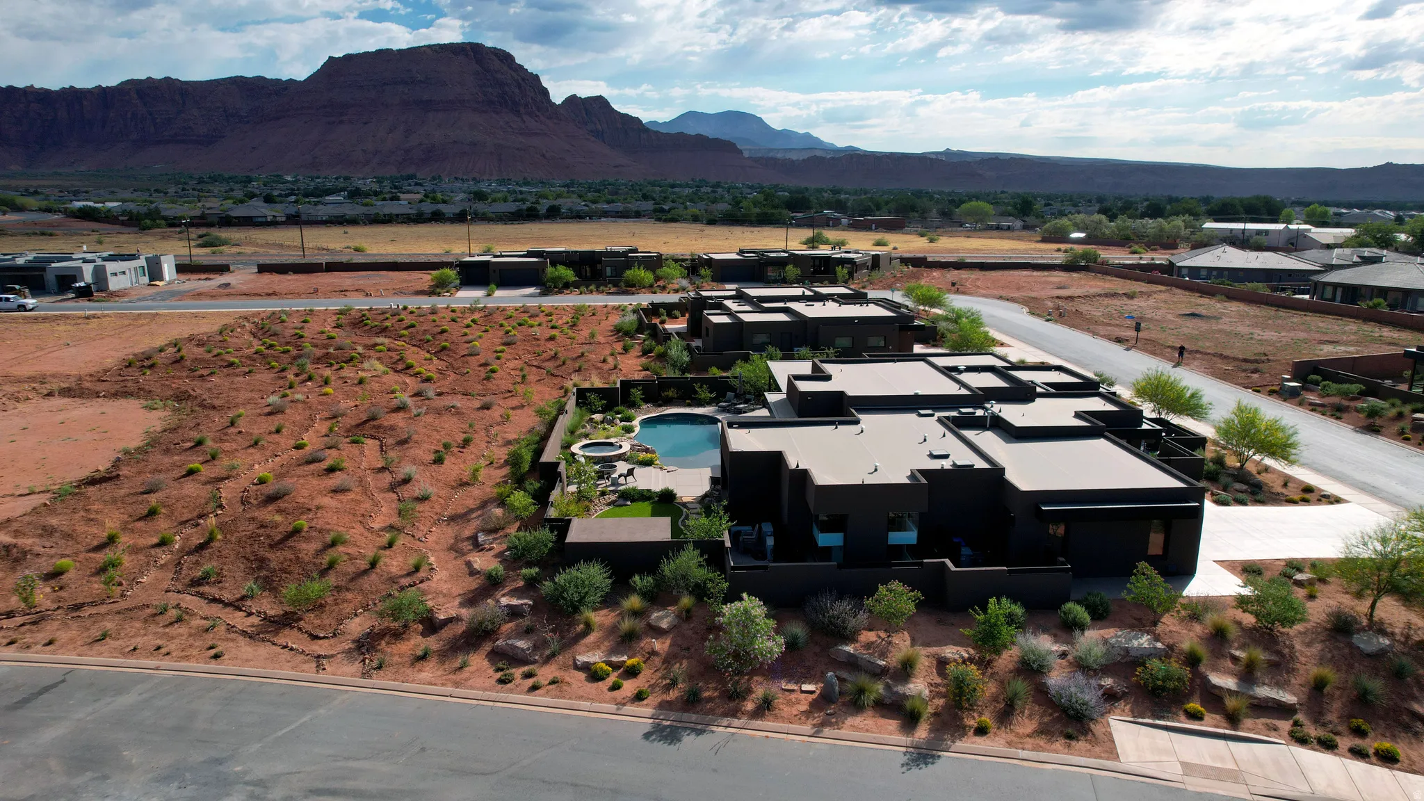Modern residential property featuring a dark exterior, a flat roofline, and an integrated swimming pool