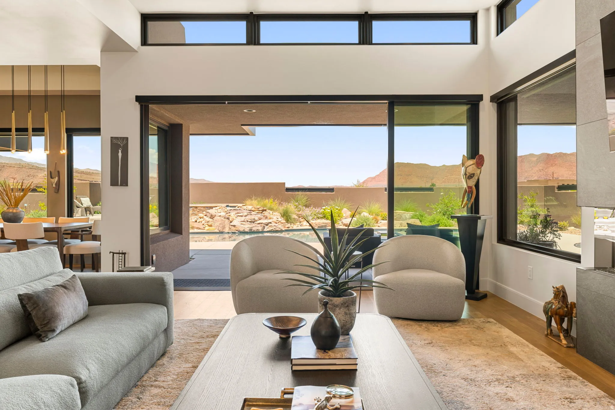 Living area with tall ceilings, clerestory windows, and a multi-panel sliding glass door opening to a patio