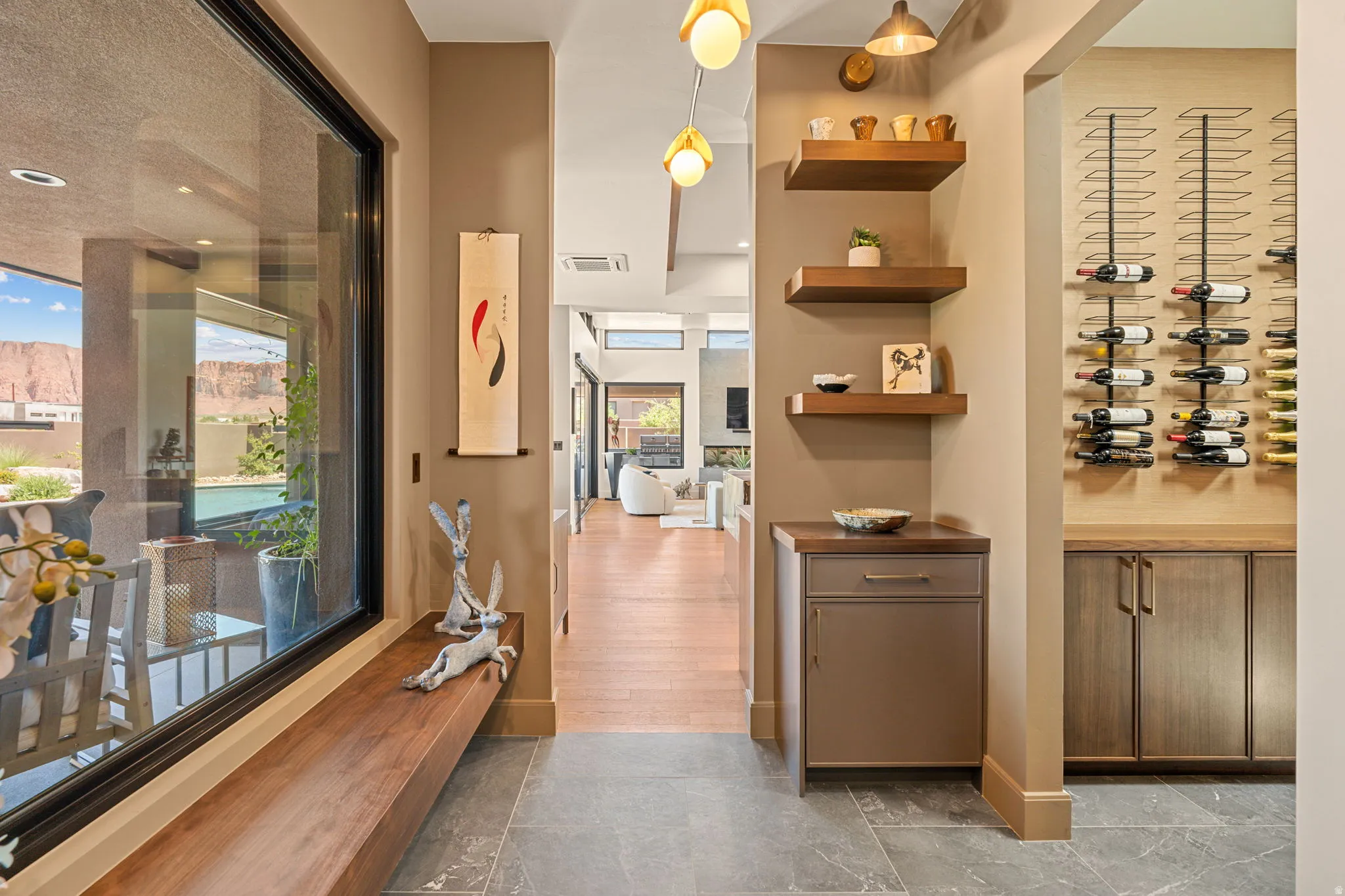 Hallway art nook featuring large format tile flooring, a custom floating bench, and a large picture window