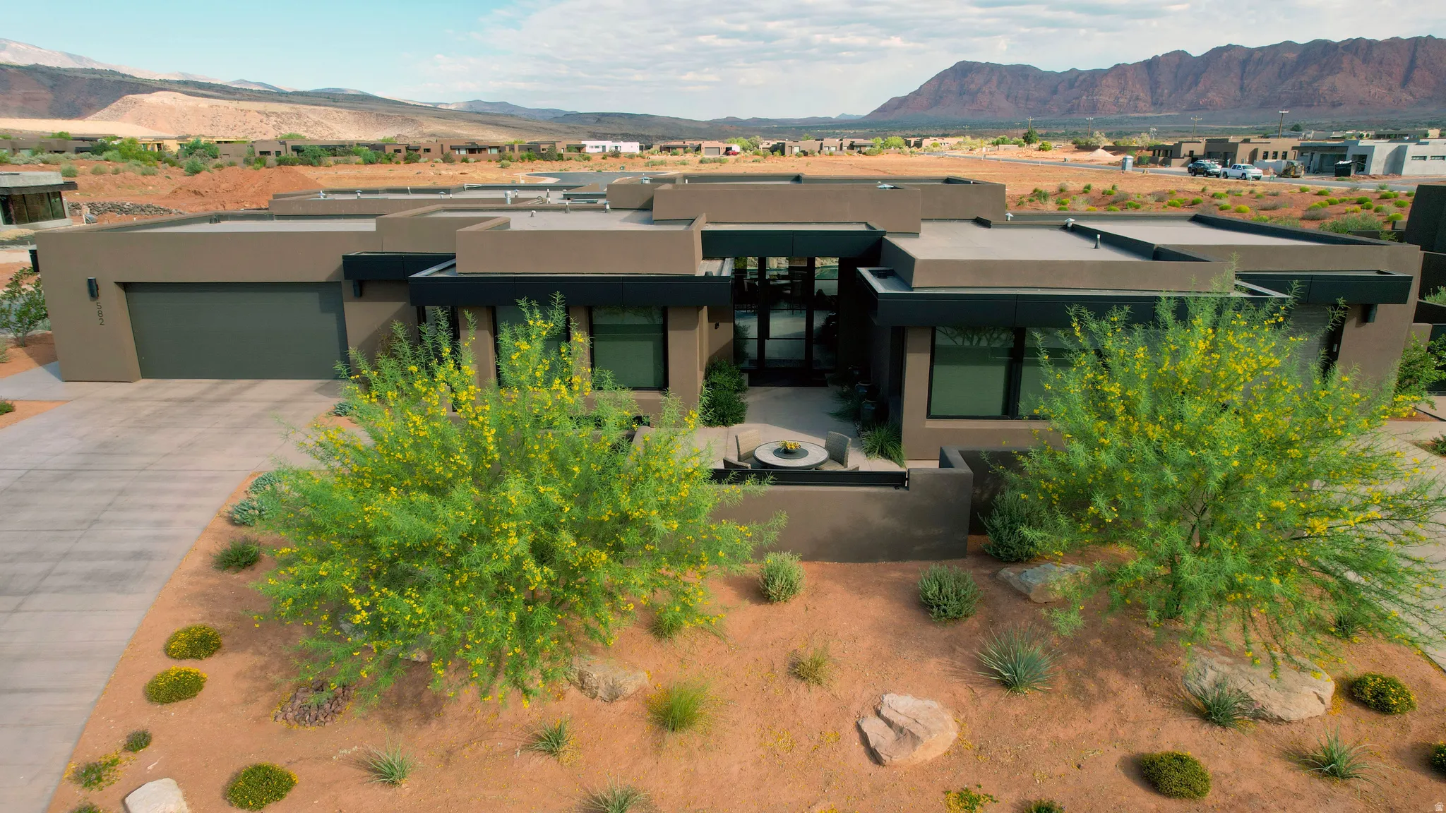 Contemporary desert architecture featuring a flat roofline, integrated garage, and a modern entrance