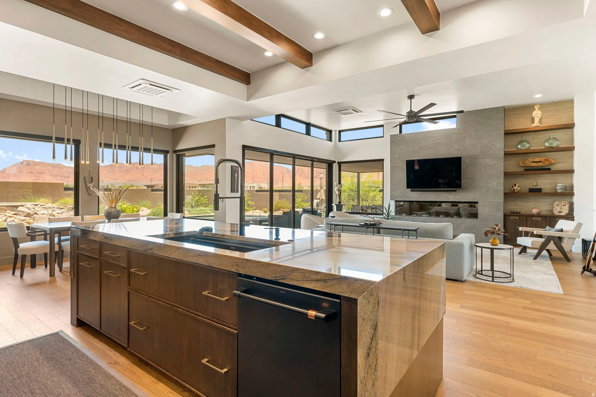 Kitchen island with integrated sink, dark wood-finish cabinetry, and a matte black built-in dishwasher