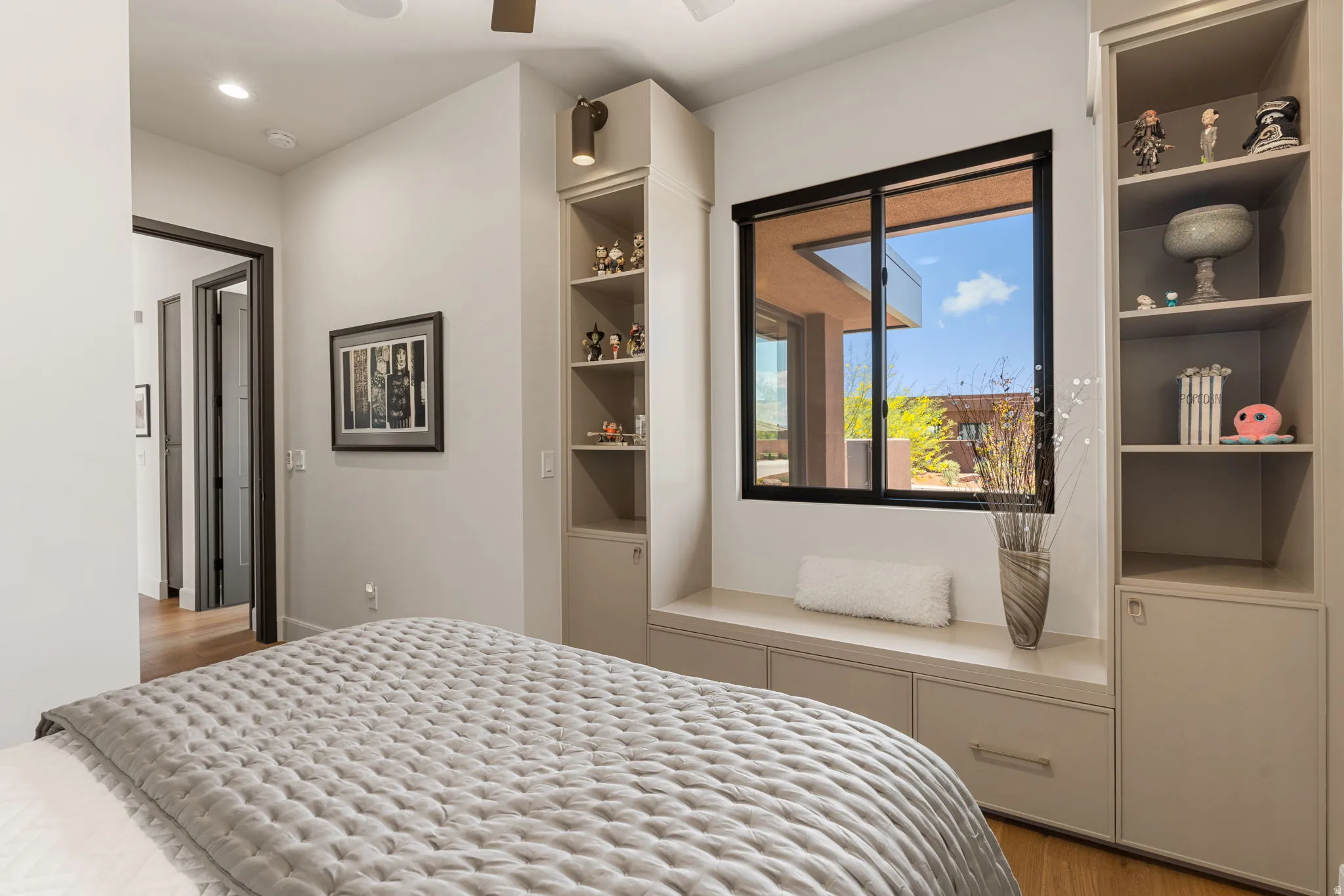 Third Bedroom featuring a built-in window seat with integrated storage, custom shelving units, and a ceiling fan